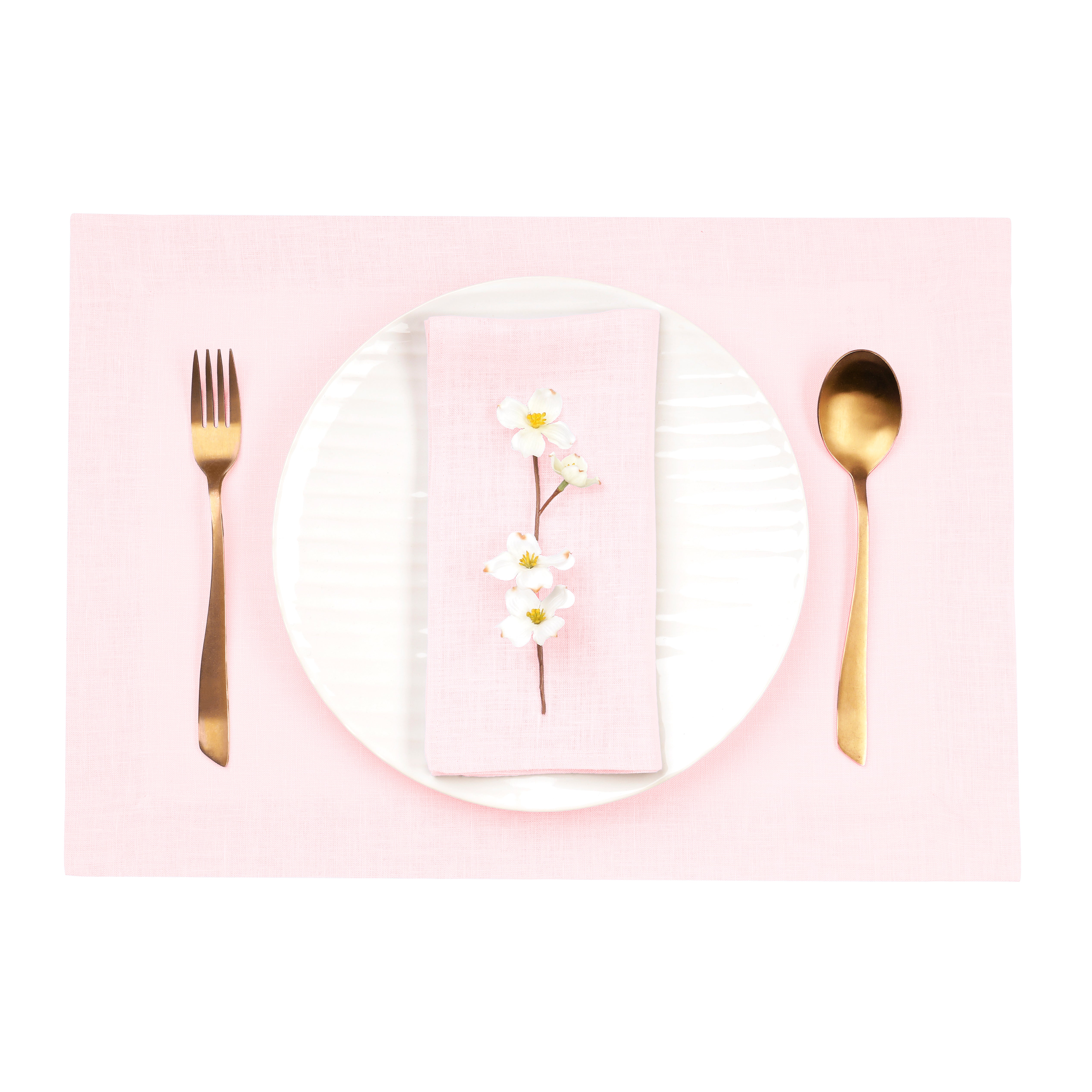 Close-up of the hemmed edge on pastel pink linen placemats