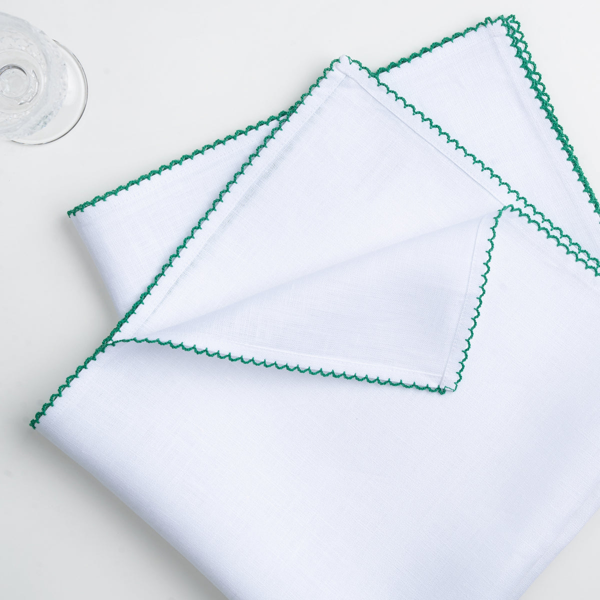 White and green pure linen dinner napkins styled on a dining table