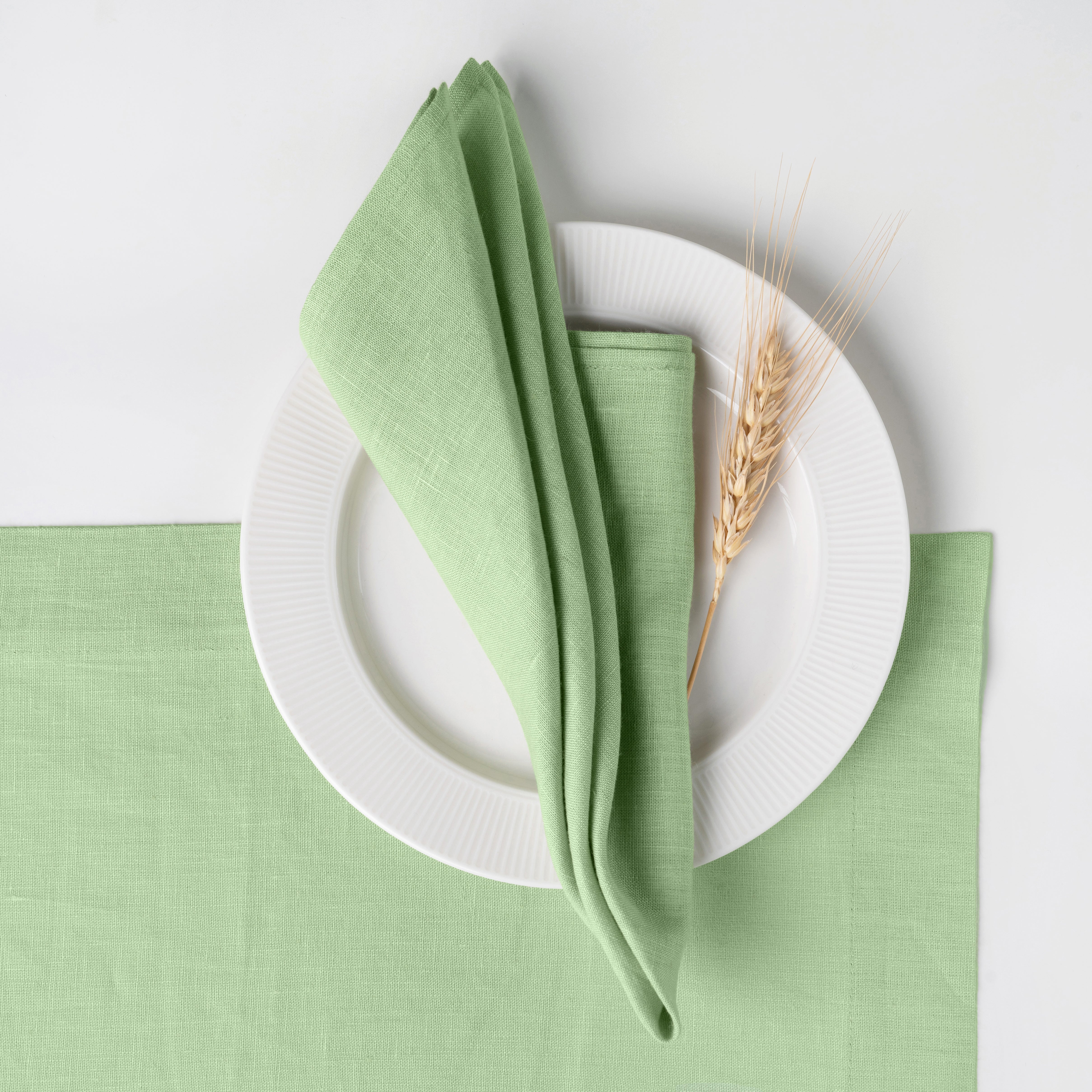 Sage green pure linen dinner napkins styled on a dining table