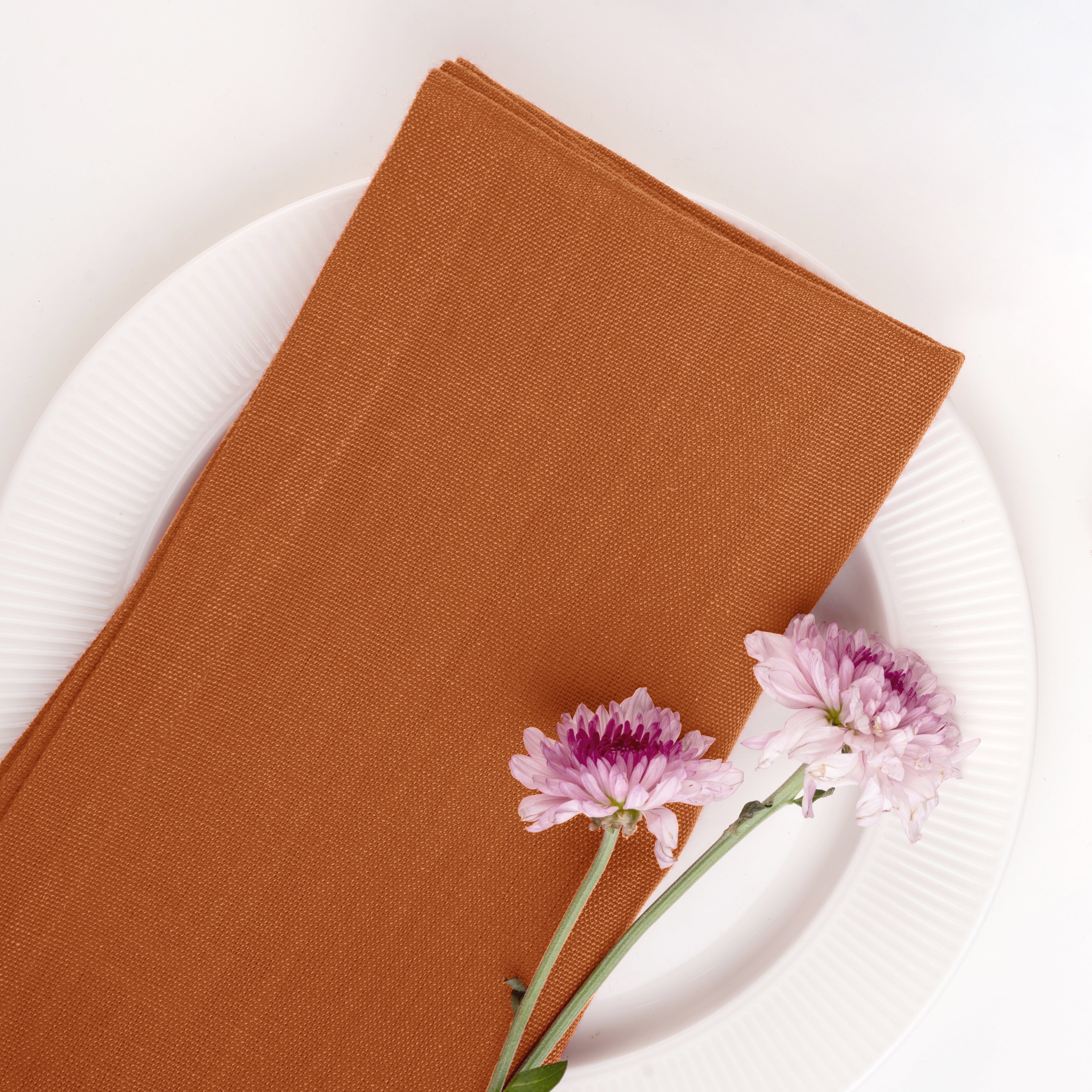 Rust pure linen dinner napkins styled on a dining table