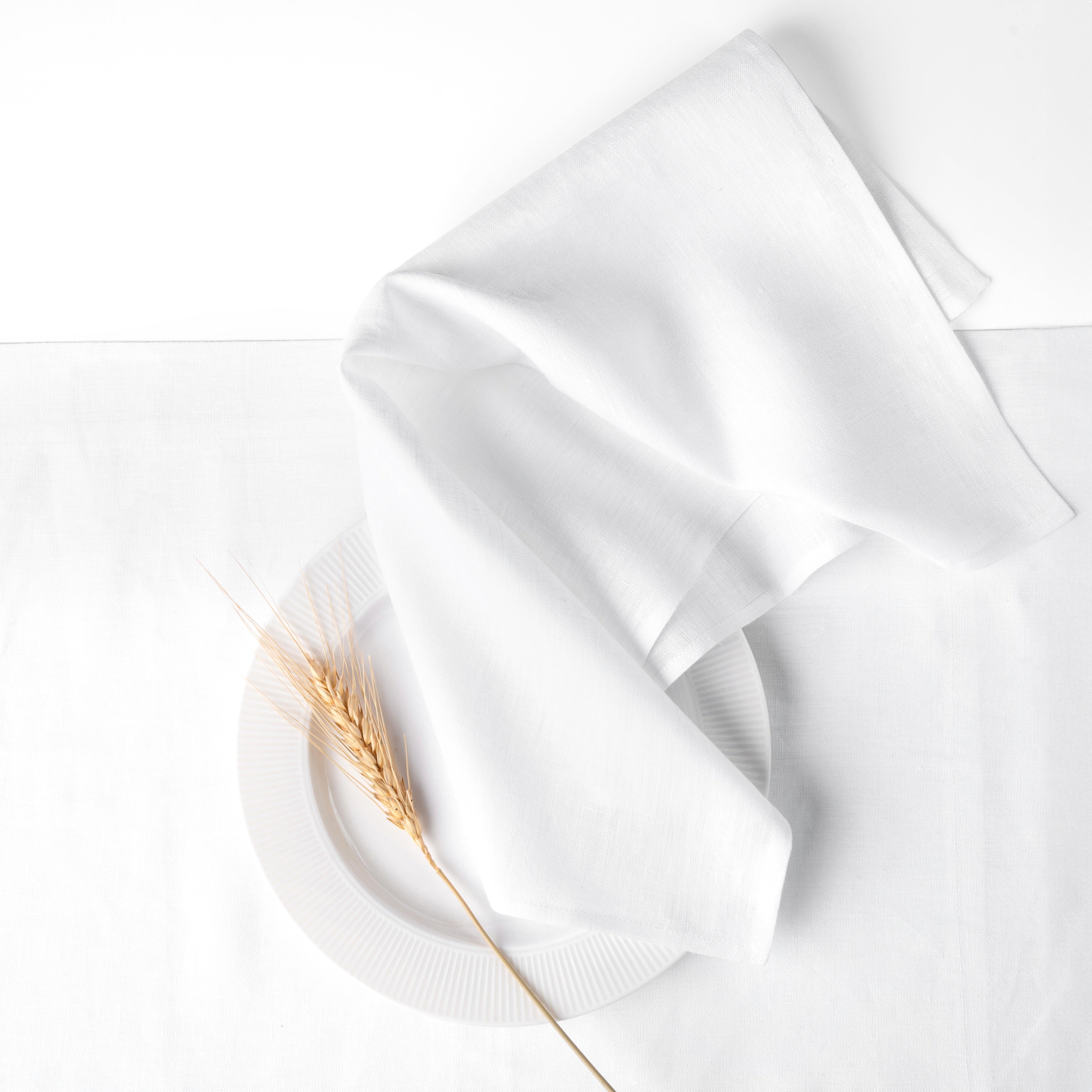 White pure linen dinner napkins styled on a dining table