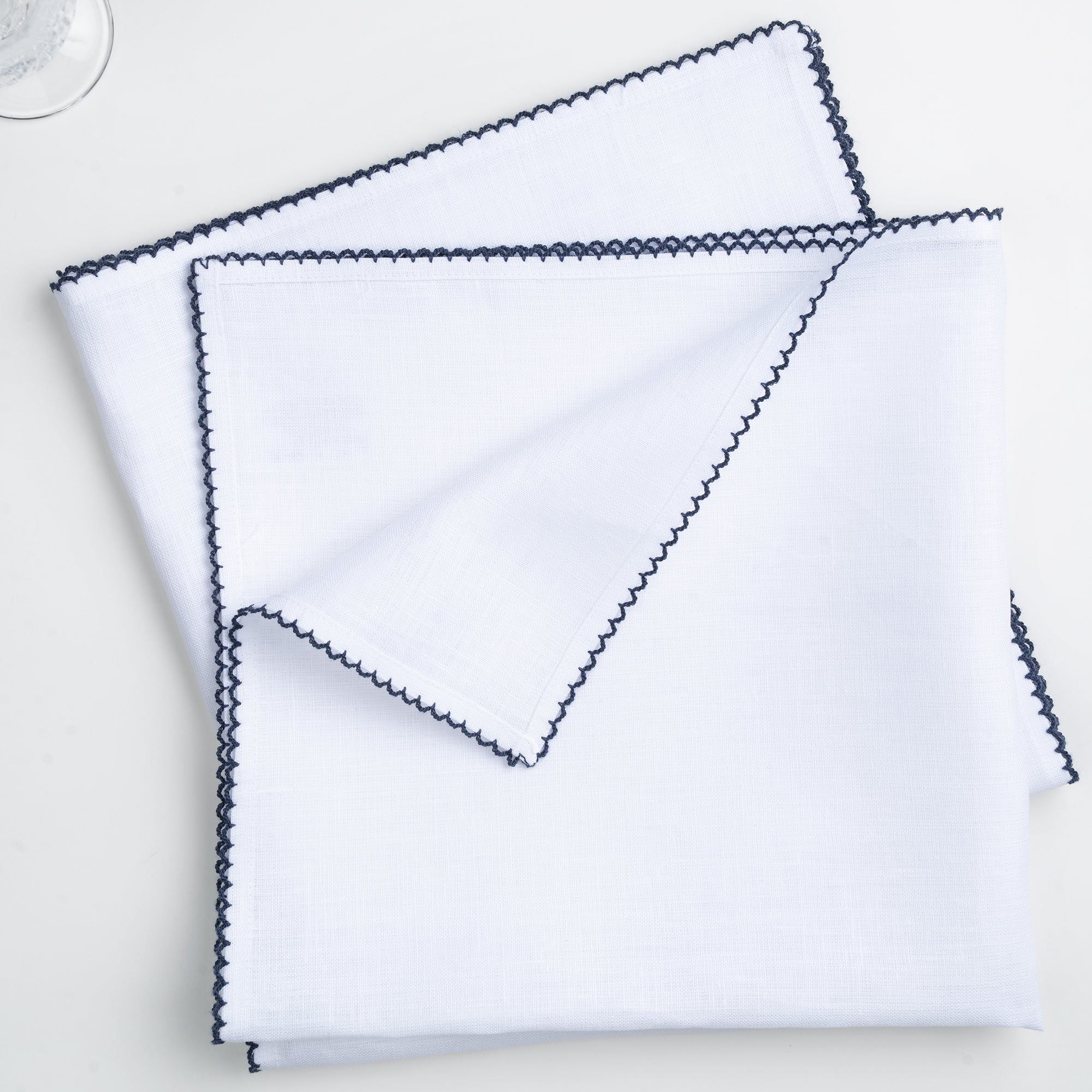 White and navy blue pure linen dinner napkins styled on a dining table