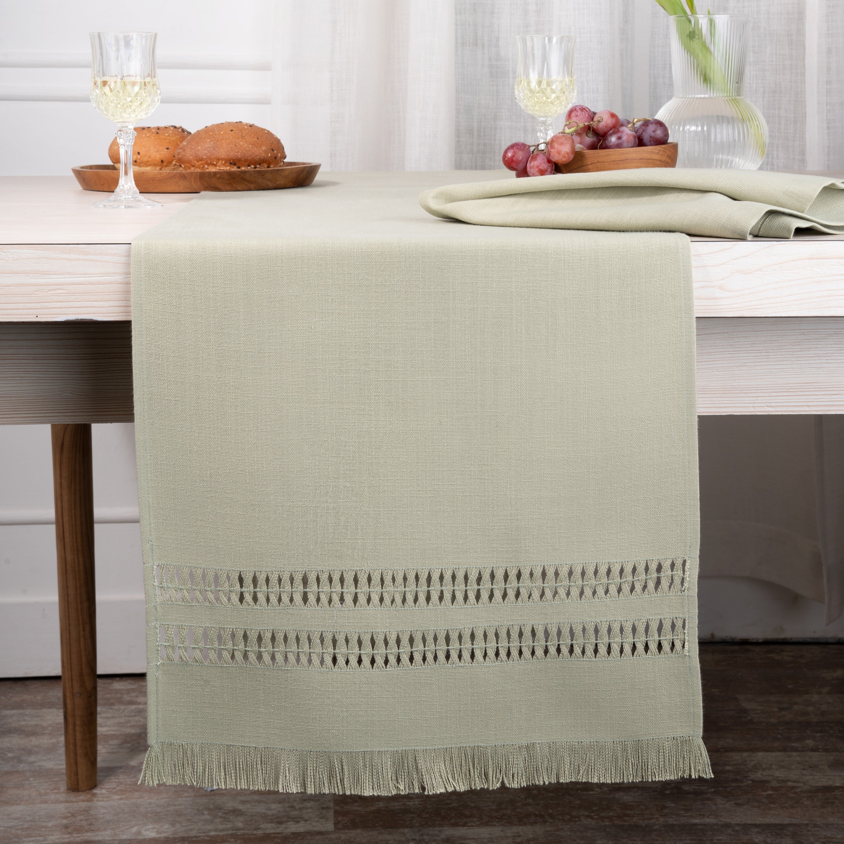 Sage green faux linen table runner styled on a dining table