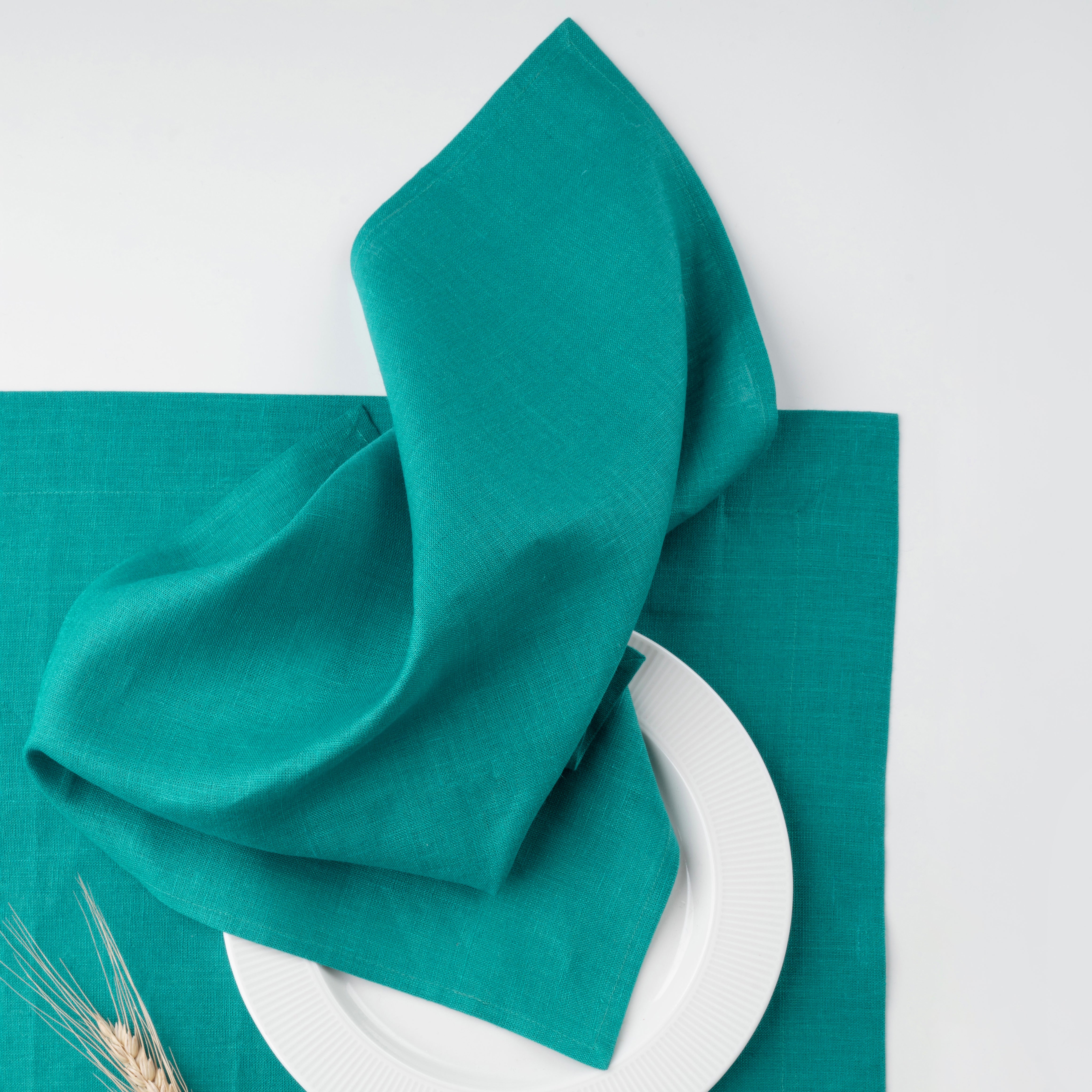 Teal blue pure linen dinner napkins styled on a dining table