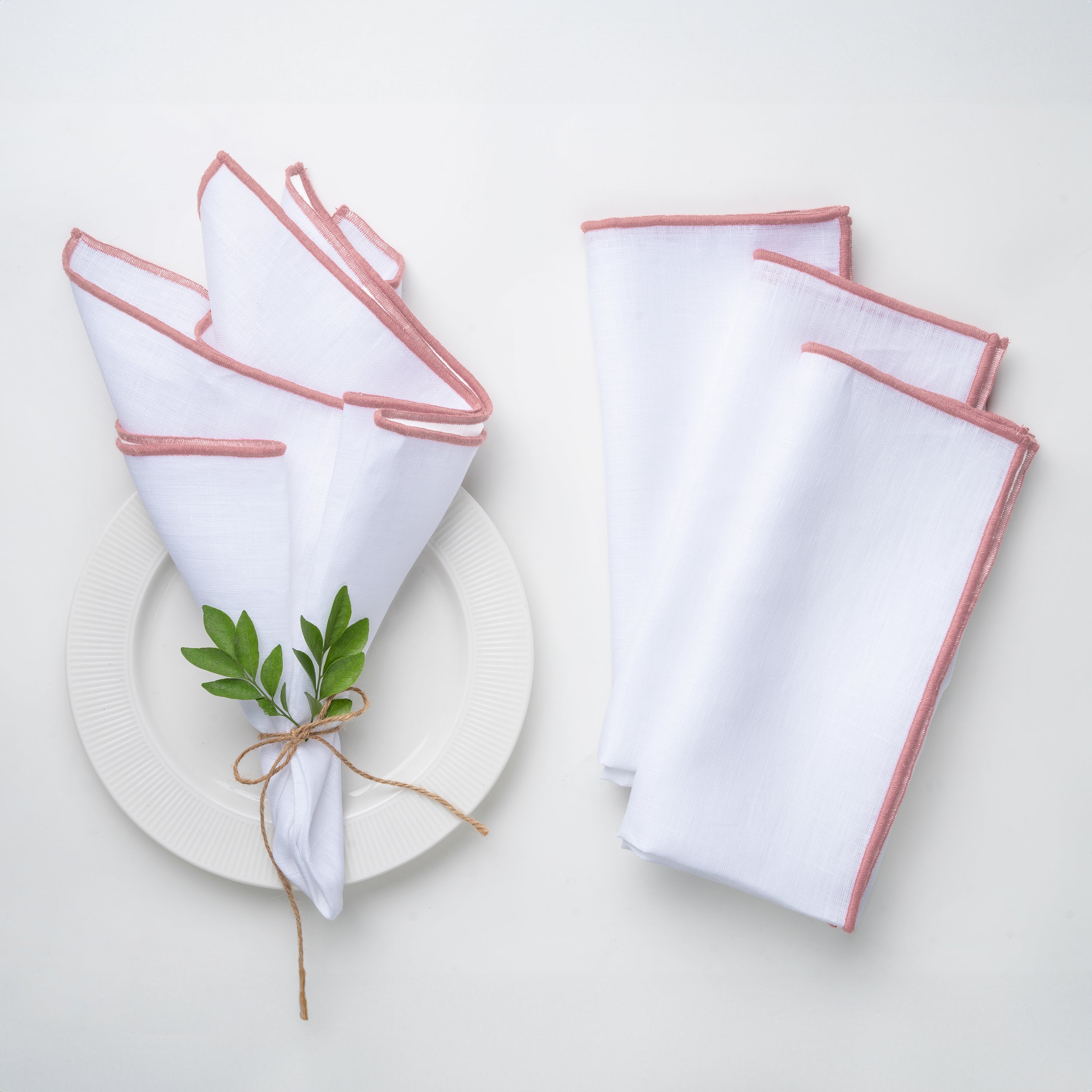 White and dusty pink pure linen dinner napkins styled on a dining table