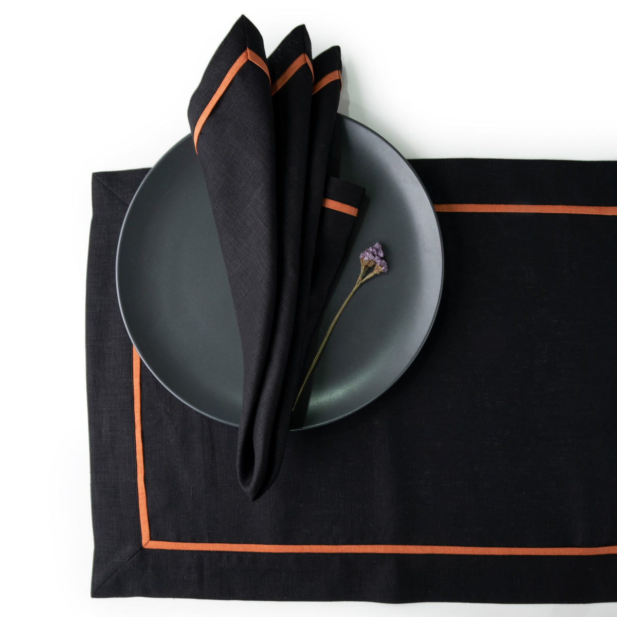 Black and rust pure linen dinner napkins styled on a dining table