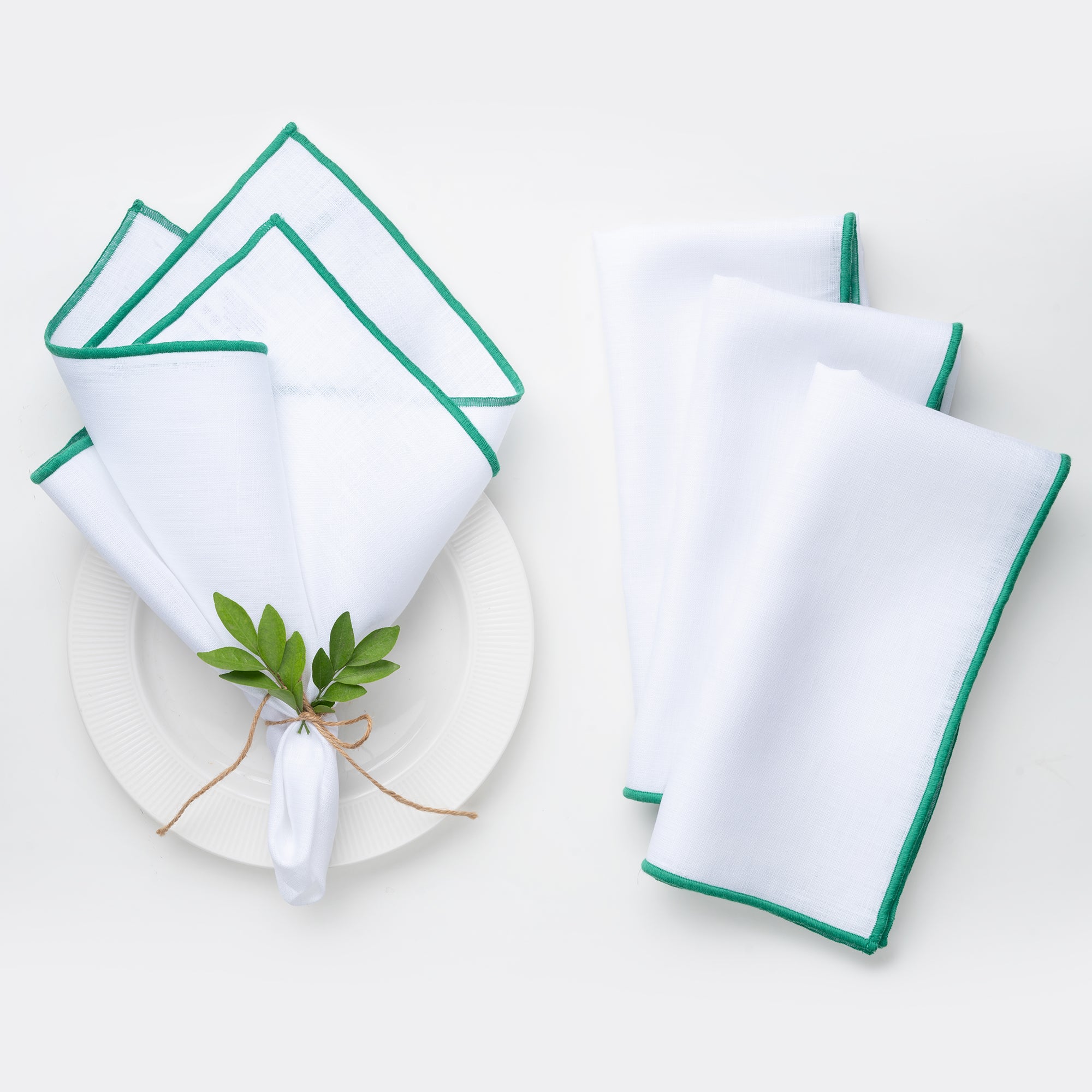 White and green pure linen dinner napkins styled on a dining table