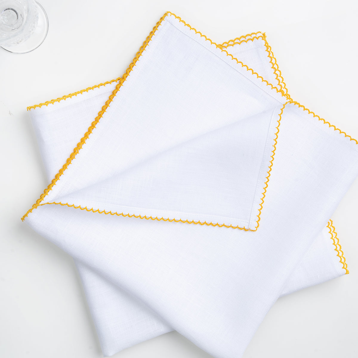 White and yellow pure linen dinner napkins styled on a dining table