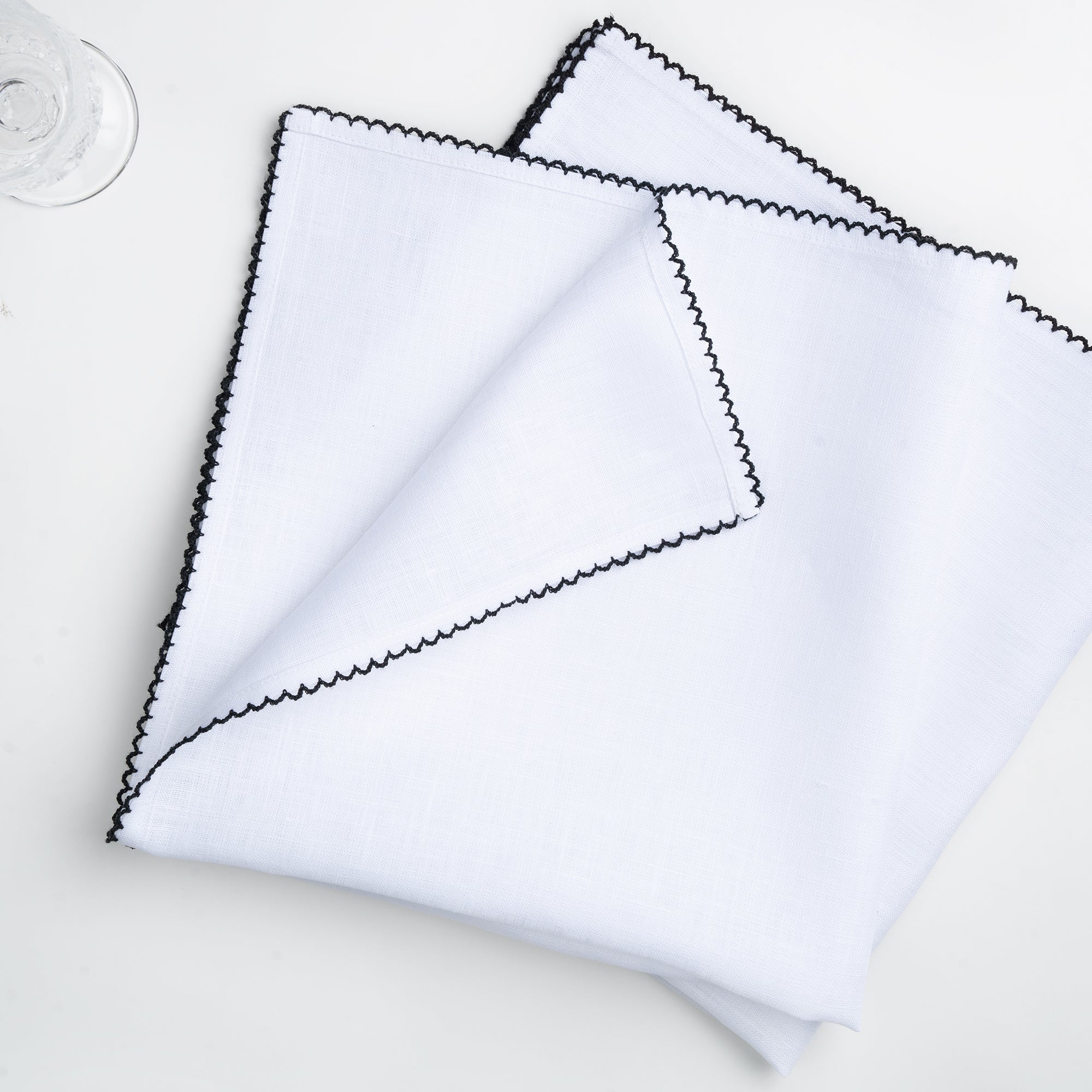 White and black pure linen dinner napkins styled on a dining table