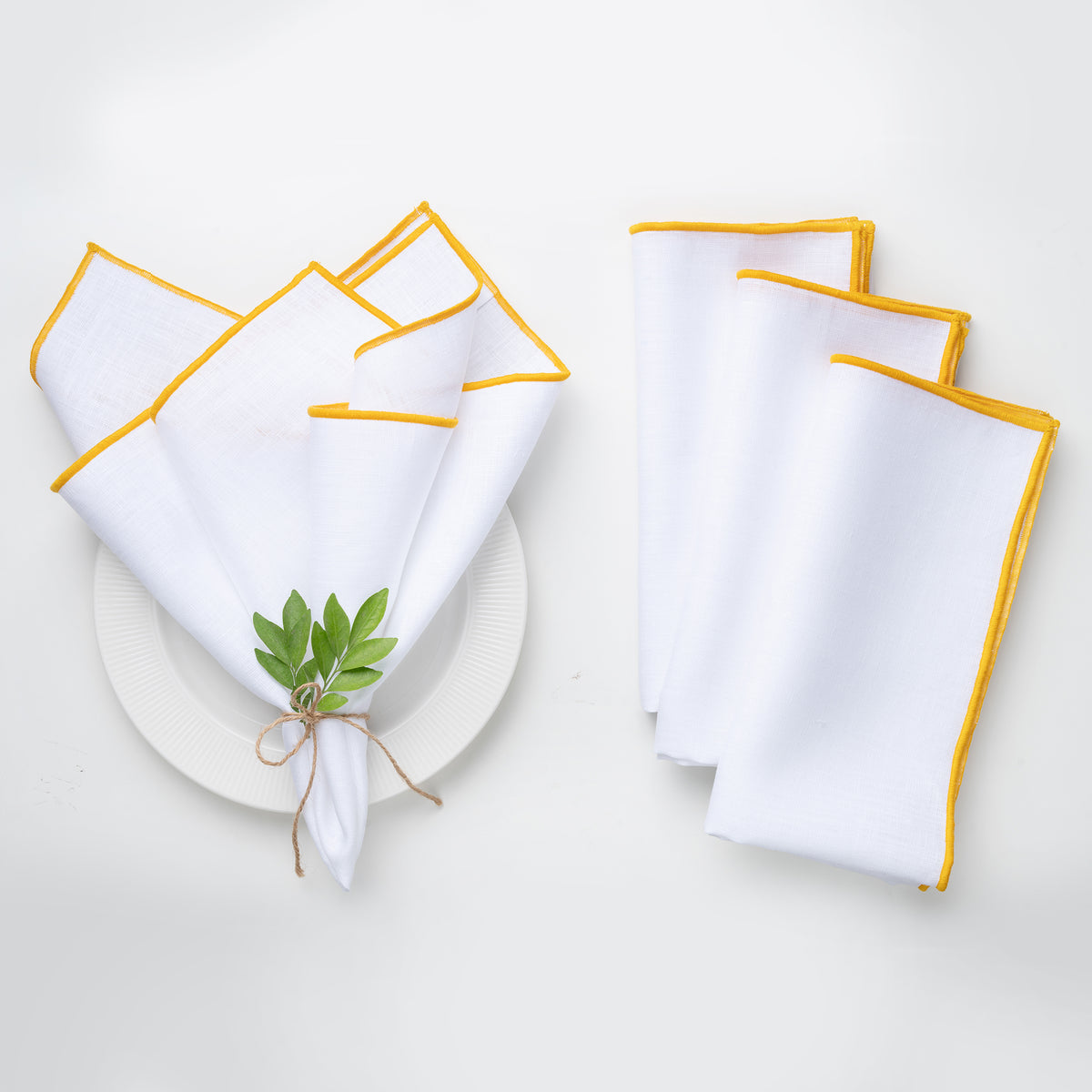 White and yellow pure linen dinner napkins styled on a dining table
