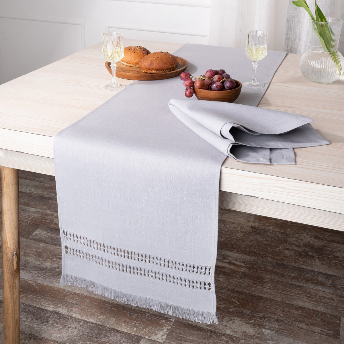 Close-up of the hand-hemstitch edge on a light grey faux linen table runner