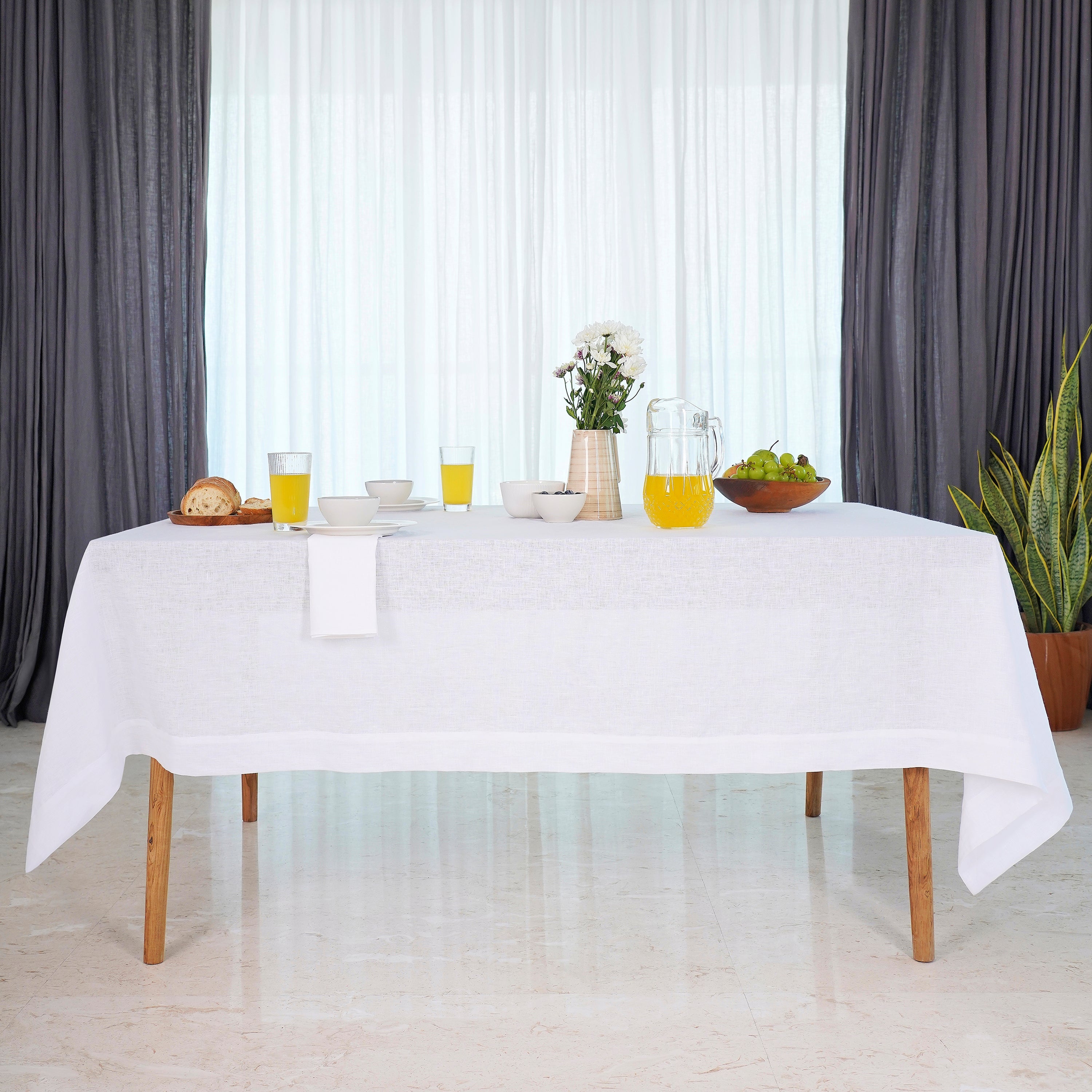 Close-up of the hemmed edge on a white linen tablecloth