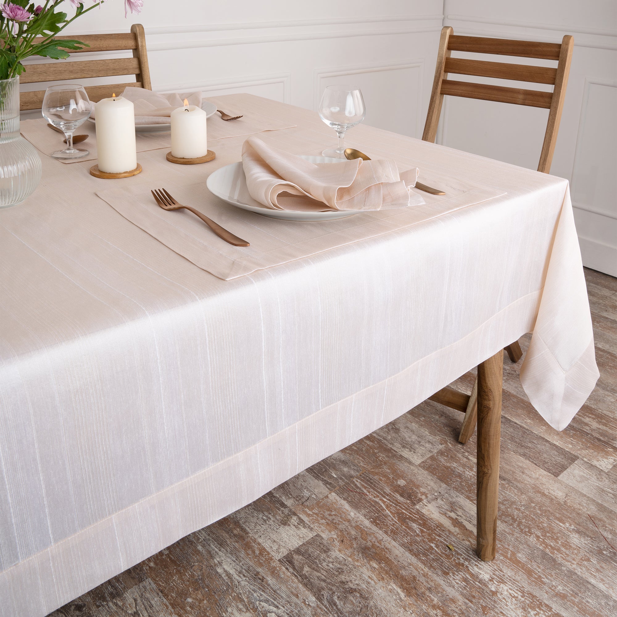 Close-up of the mitered corners on a light natural Luxe Shine tablecloth