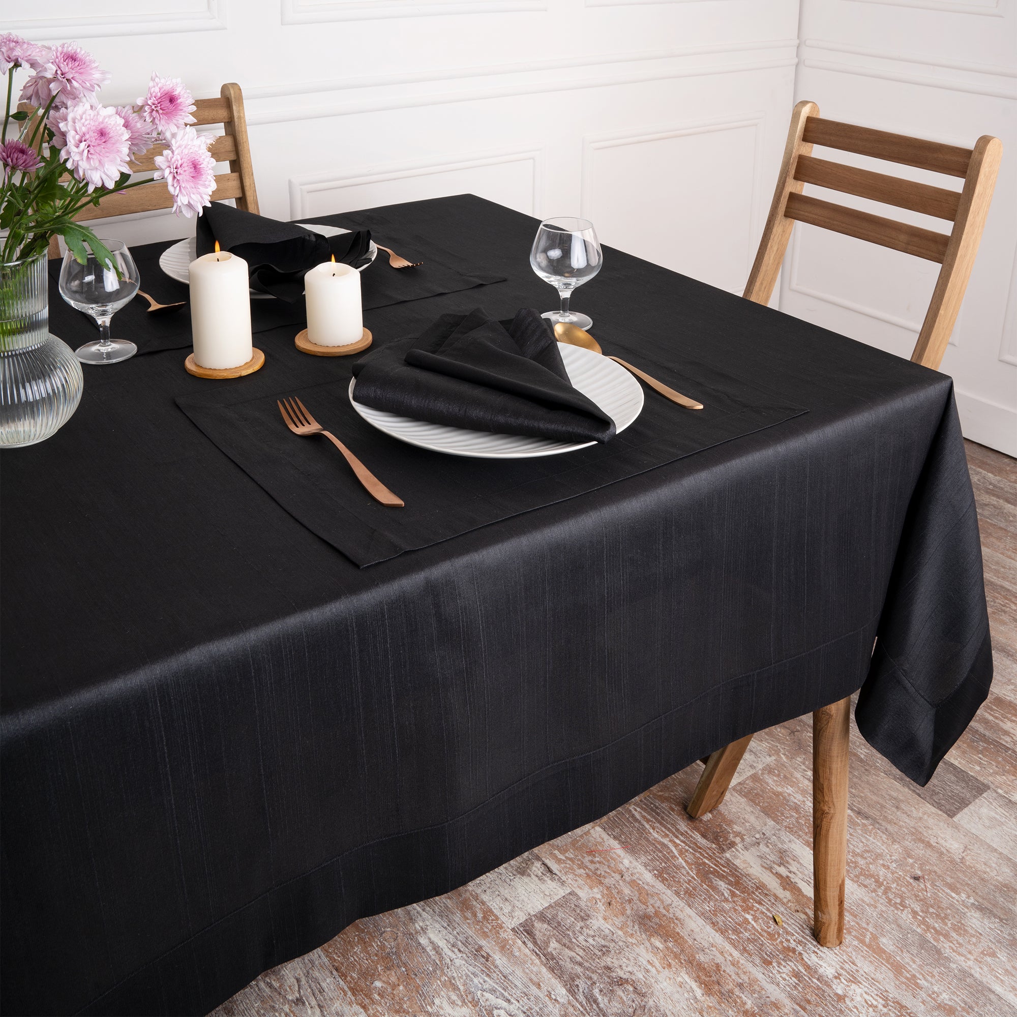 Close-up of the mitered corners on a black Luxe Shine tablecloth