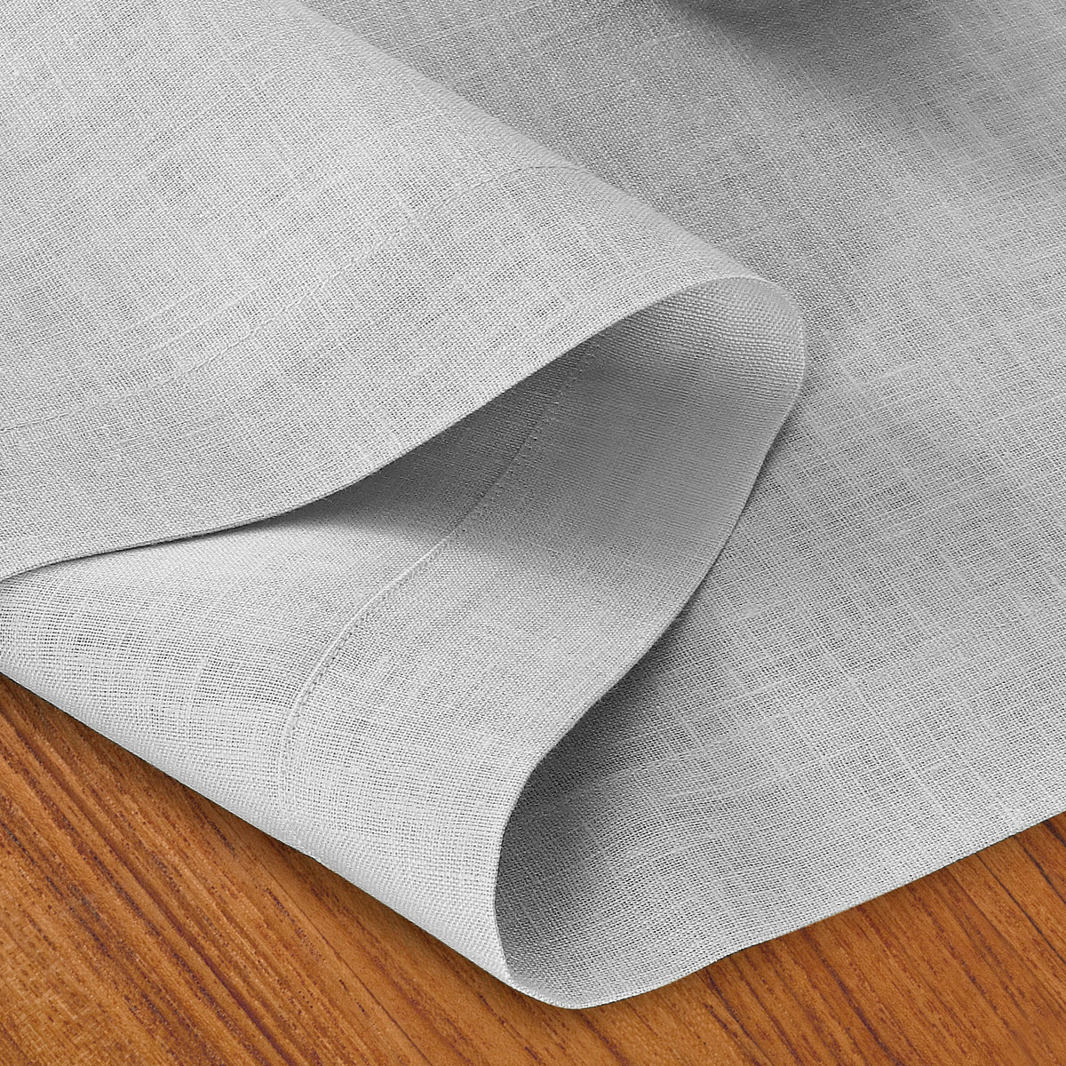 Close-up of the hemmed edge on a silver grey linen table runner