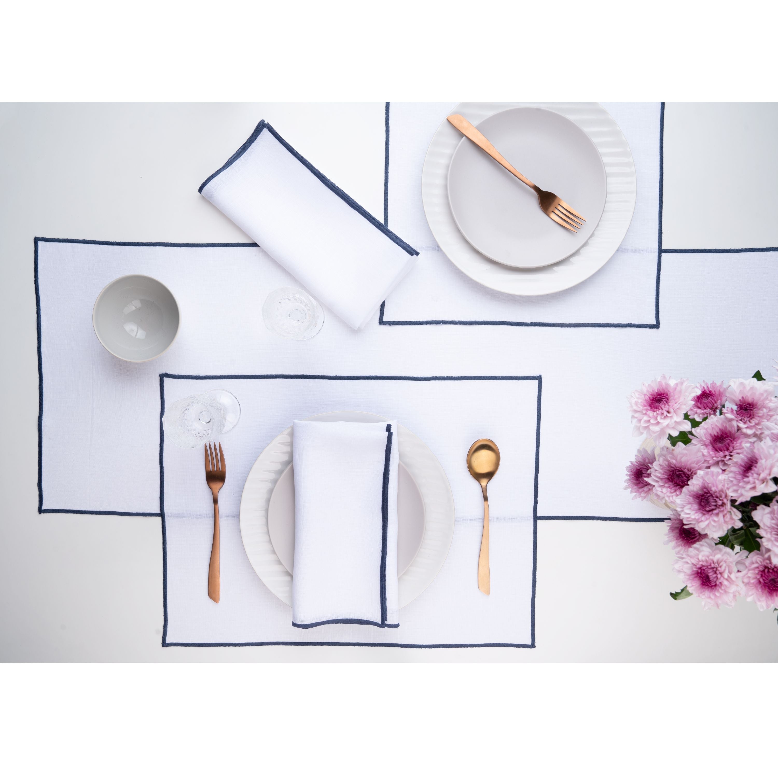 White and navy blue pure linen placemats folded to show fabric texture