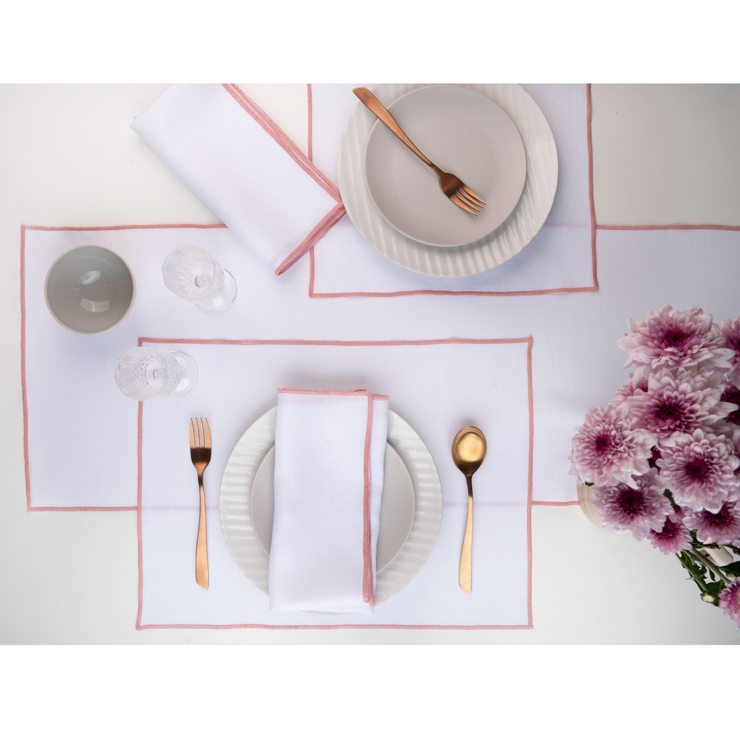 White and dusty pink pure linen placemats folded to show fabric texture