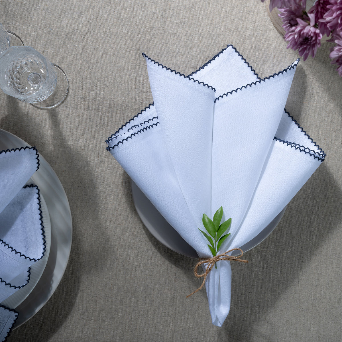 Close-up of the whipstitch edge on white and navy blue pure linen dinner napkins