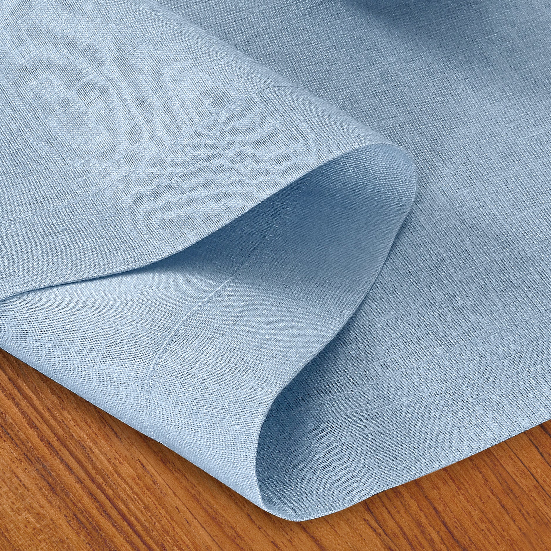 Close-up of the mitered corners on a powder blue pure linen table runner