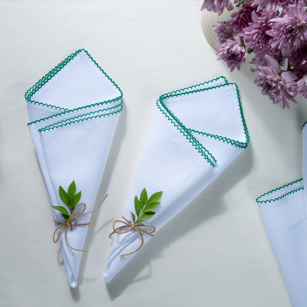 Close-up of the whipstitch edge on white and green pure linen dinner napkins