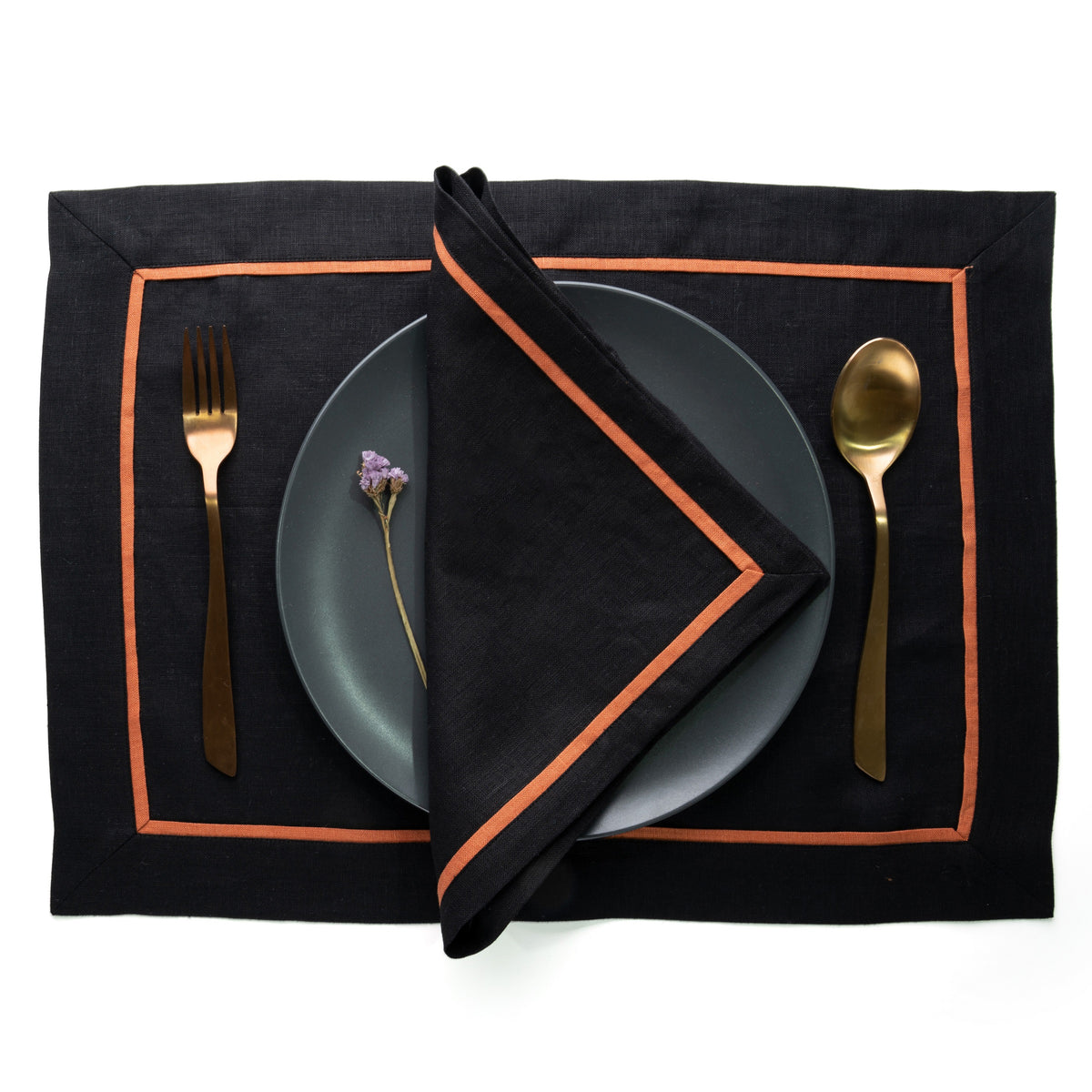 Close-up of the reversible design on black and rust pure linen dinner napkins