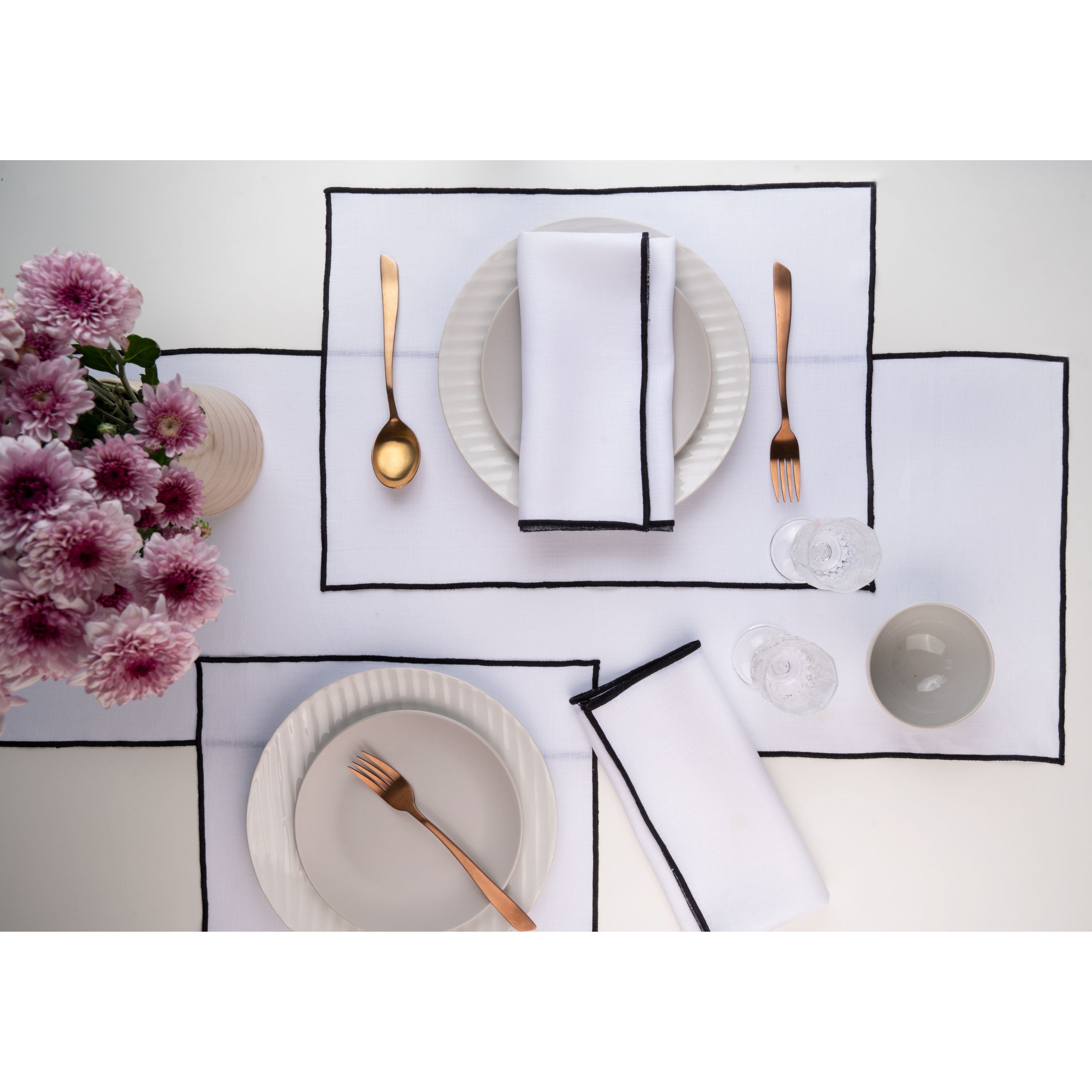 White and black pure linen placemats folded to show fabric texture