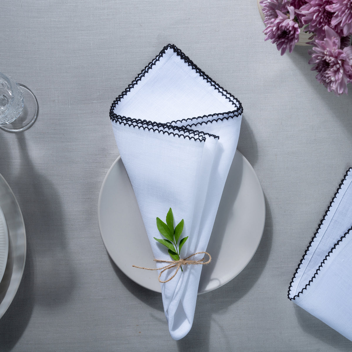 Close-up of the whipstitch edge on white and black pure linen dinner napkins