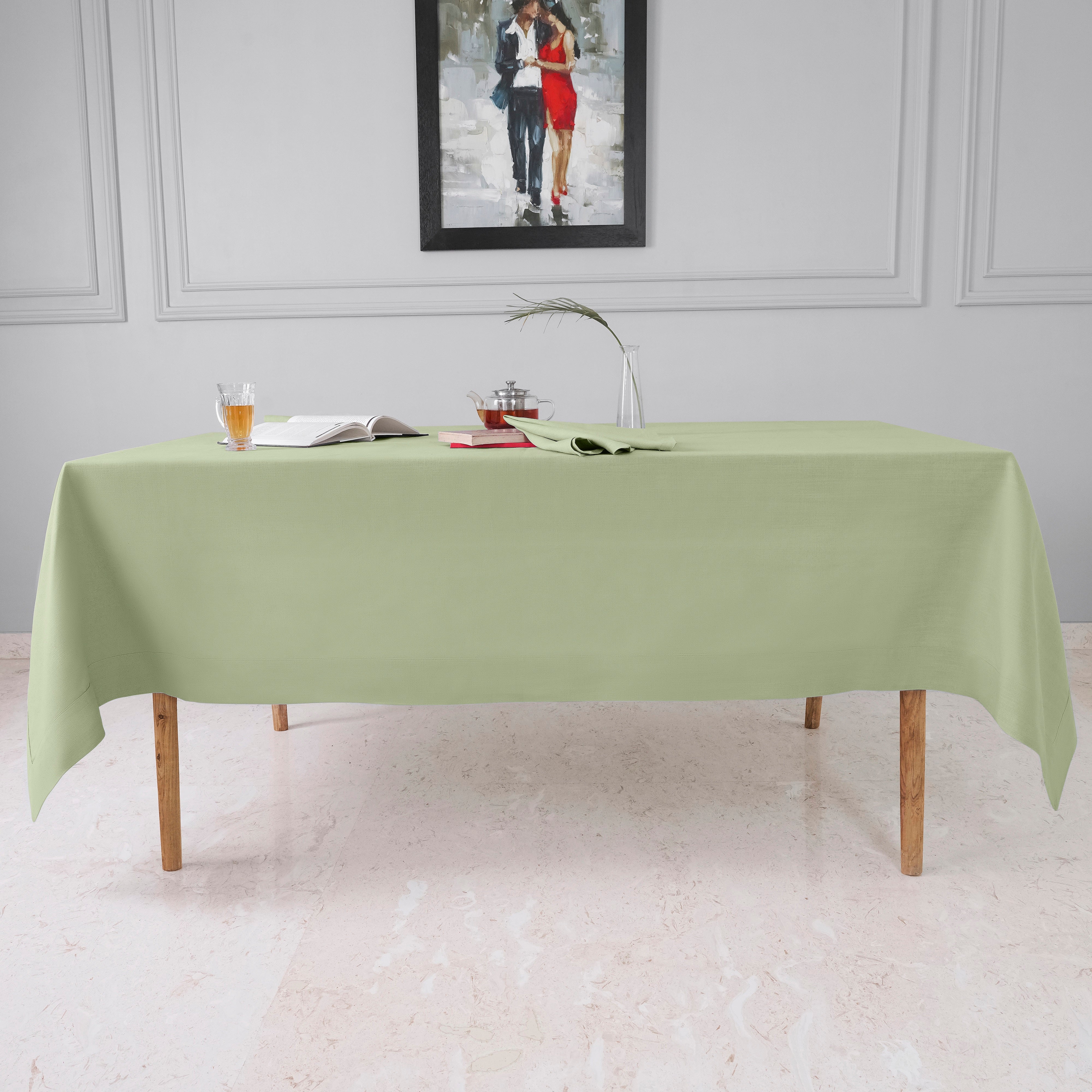 Close-up of the mitered corners on a sage green faux linen tablecloth