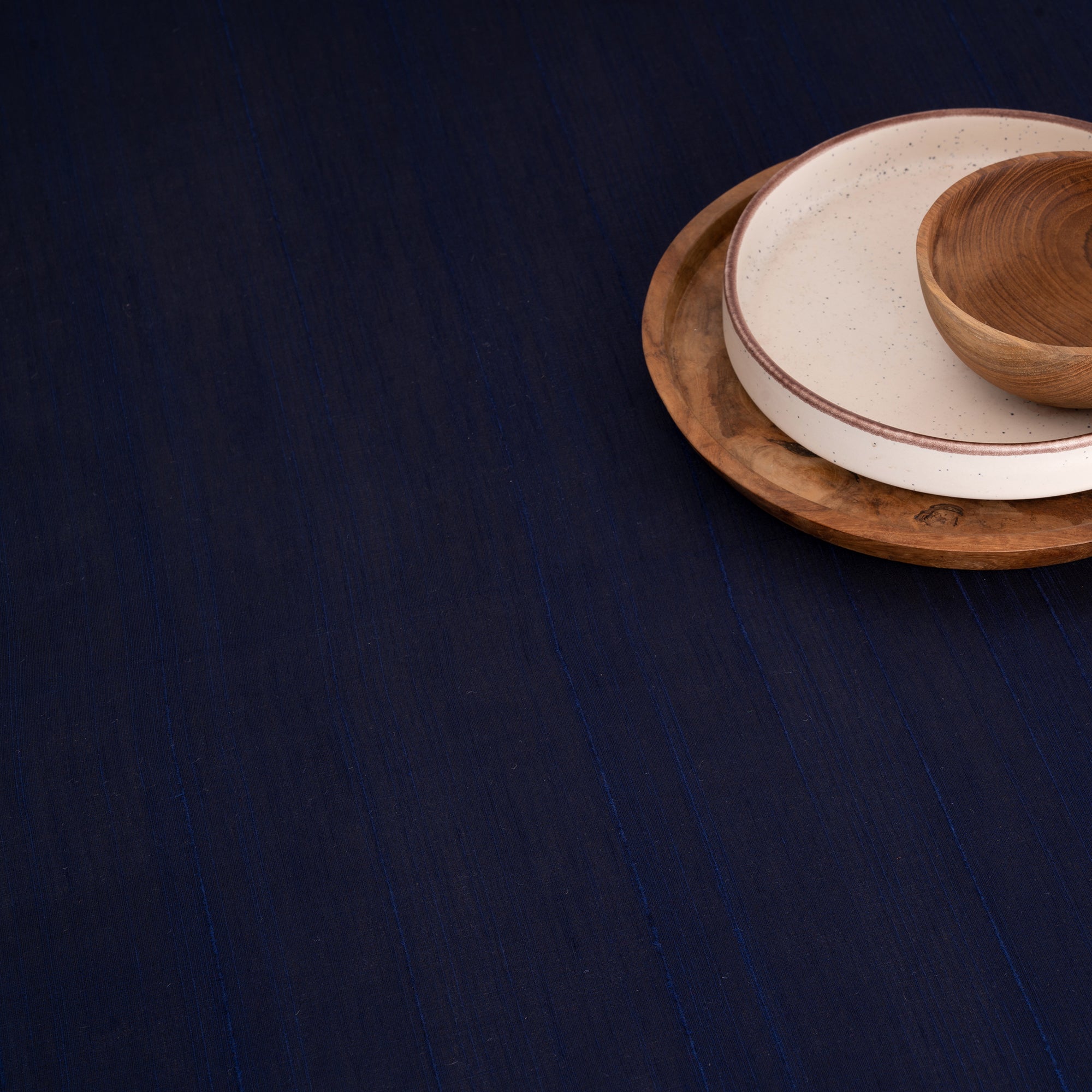 Navy blue Luxe Shine tablecloth with matching D'Moksha table linens