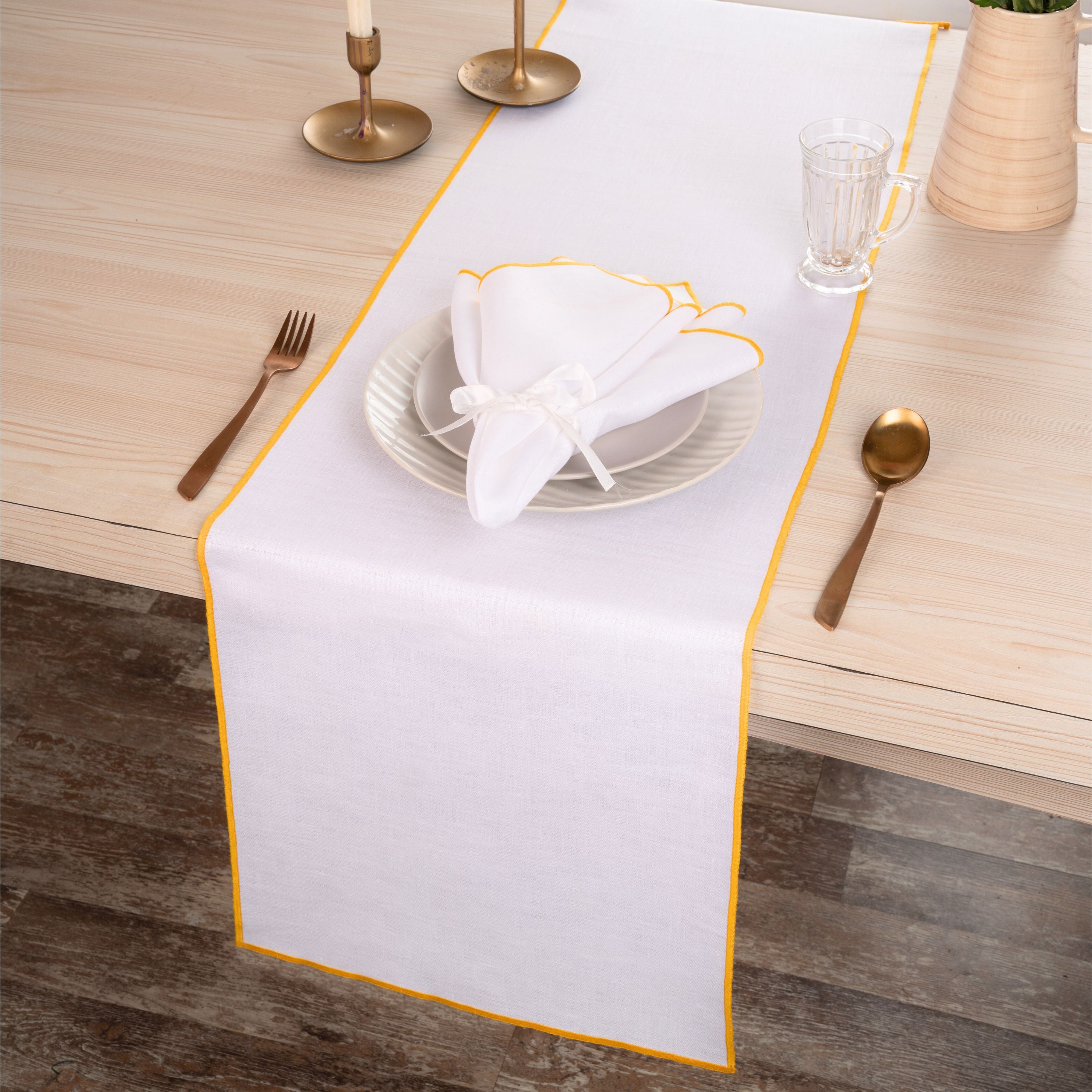 Close-up of the marrow edge on a white and yellow pure linen table runner