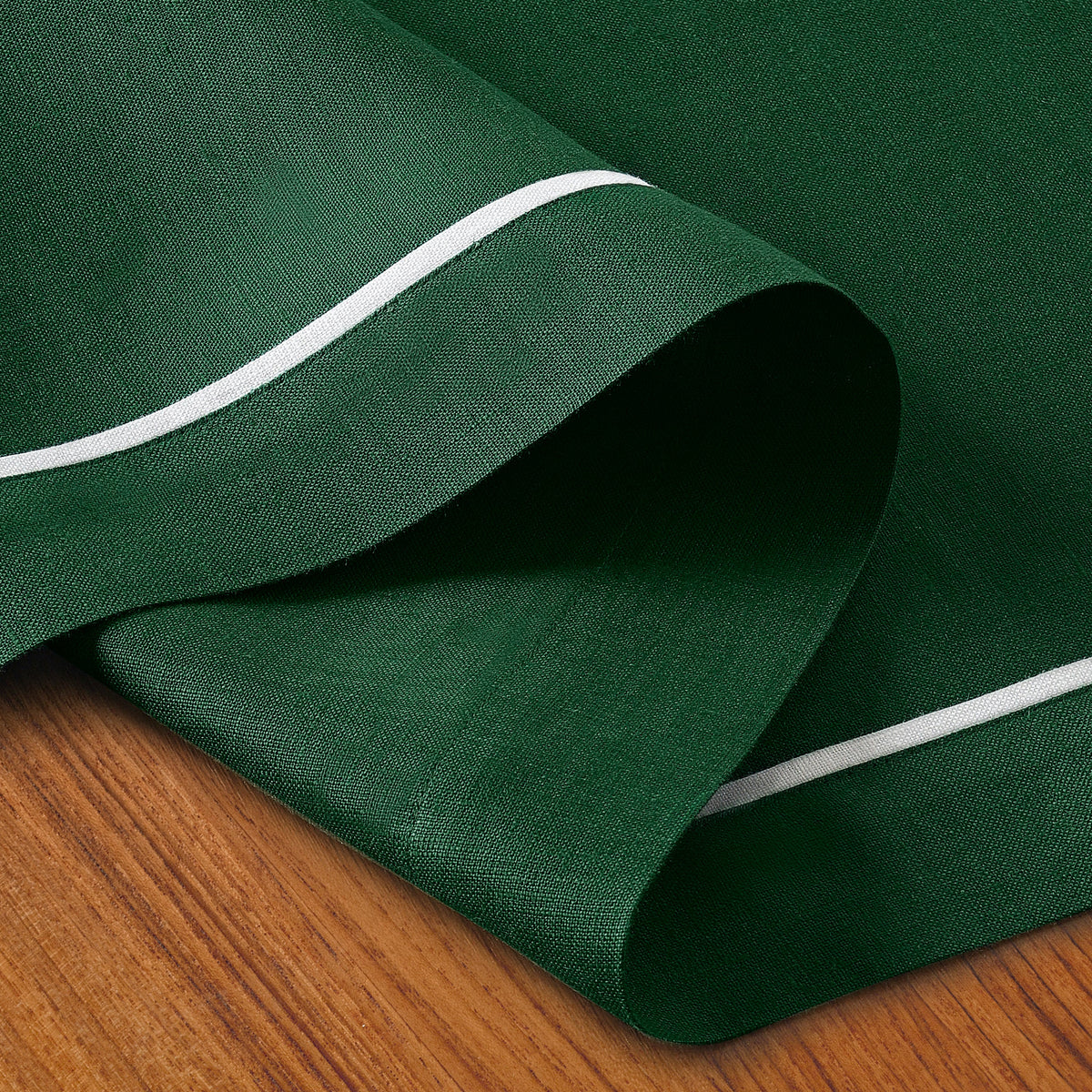 Forest green and white linen table runner folded to show fabric texture