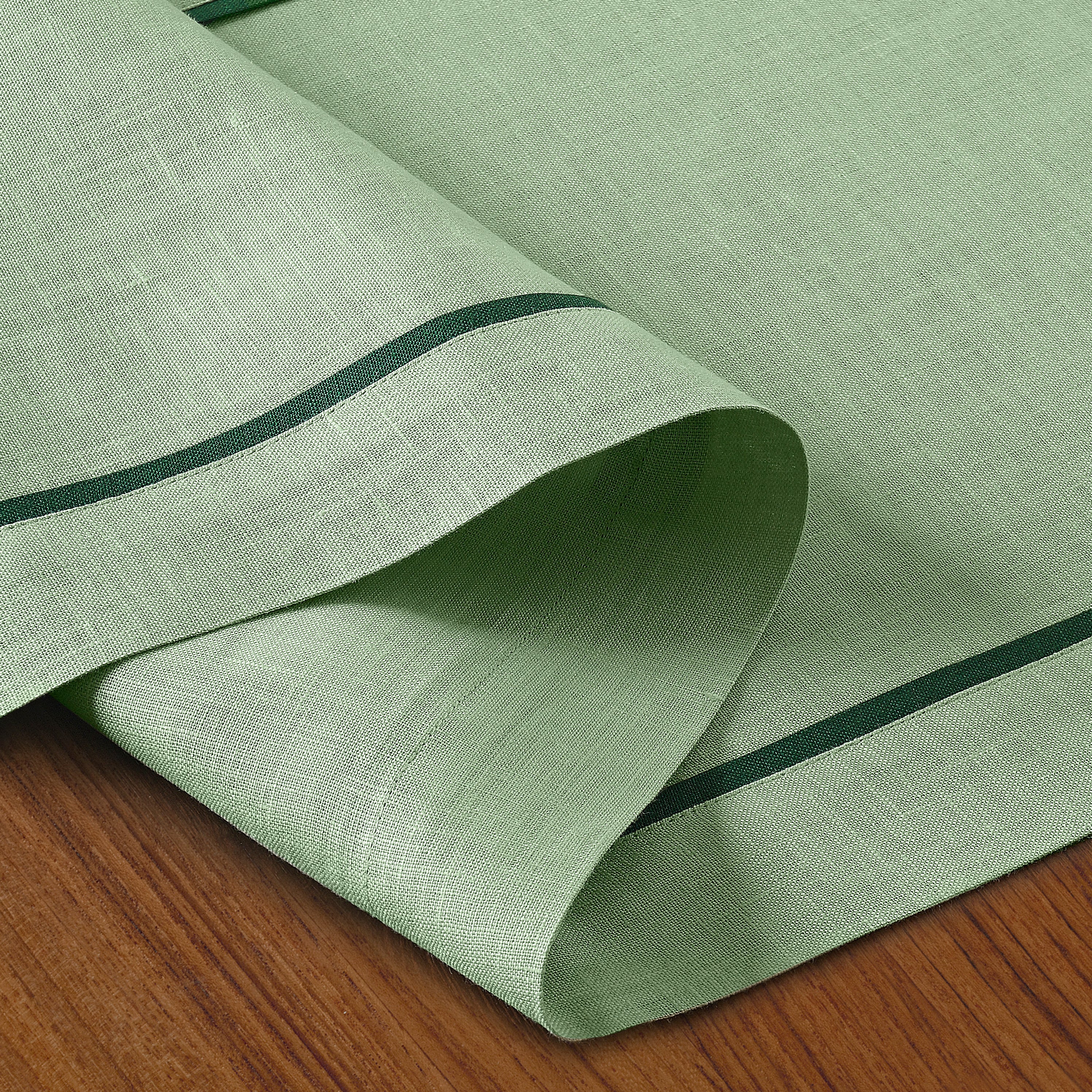 Sage green and forest pure linen table runner folded to show fabric texture