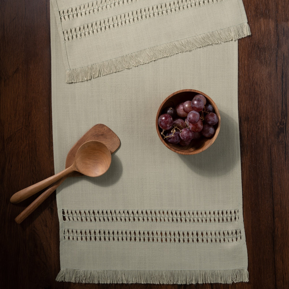 Sage green faux linen table runner in a set table setting