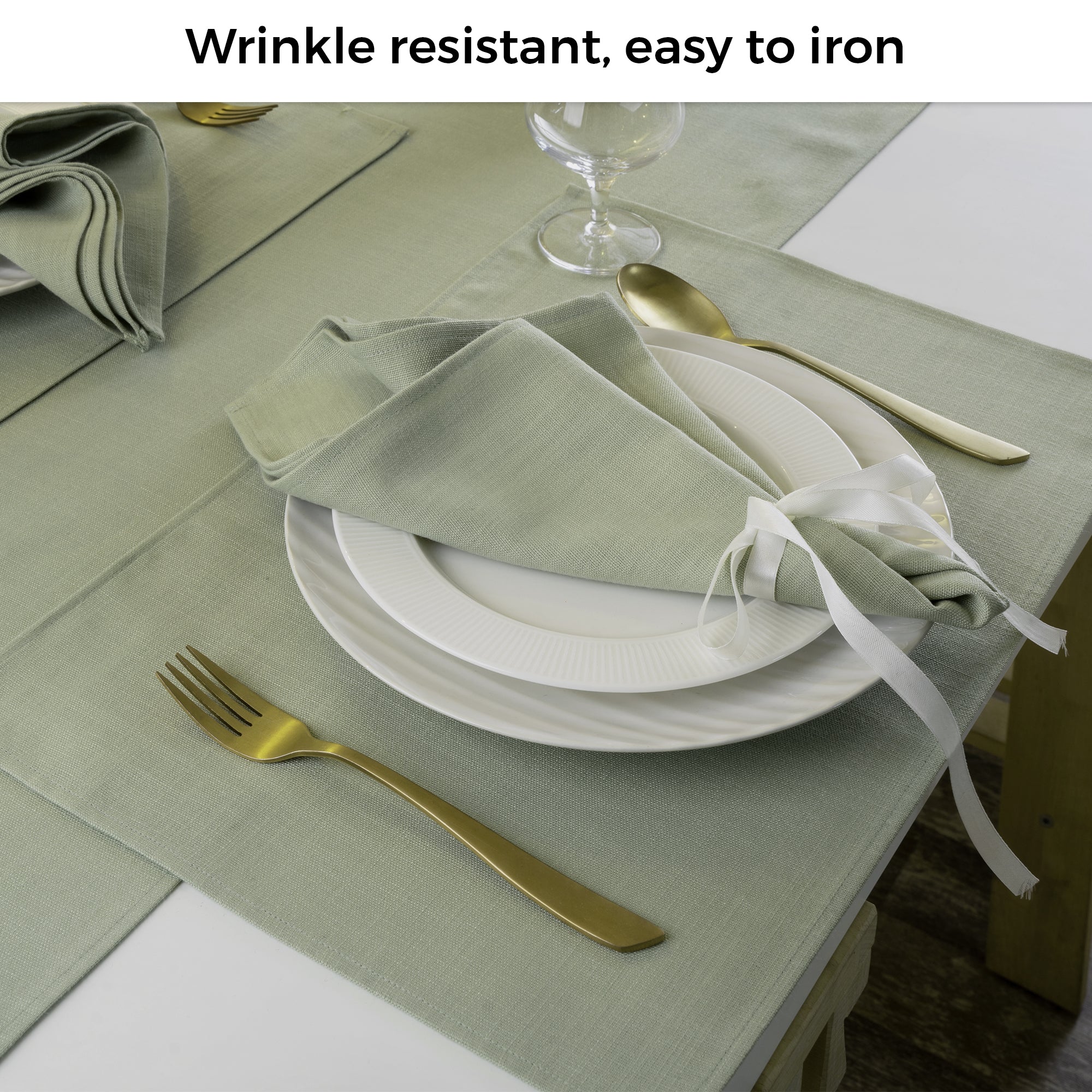 Sage green faux linen placemats folded to show fabric texture