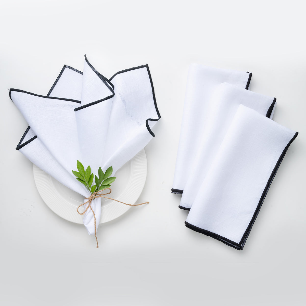 White and black pure linen dinner napkins styled on a dining table