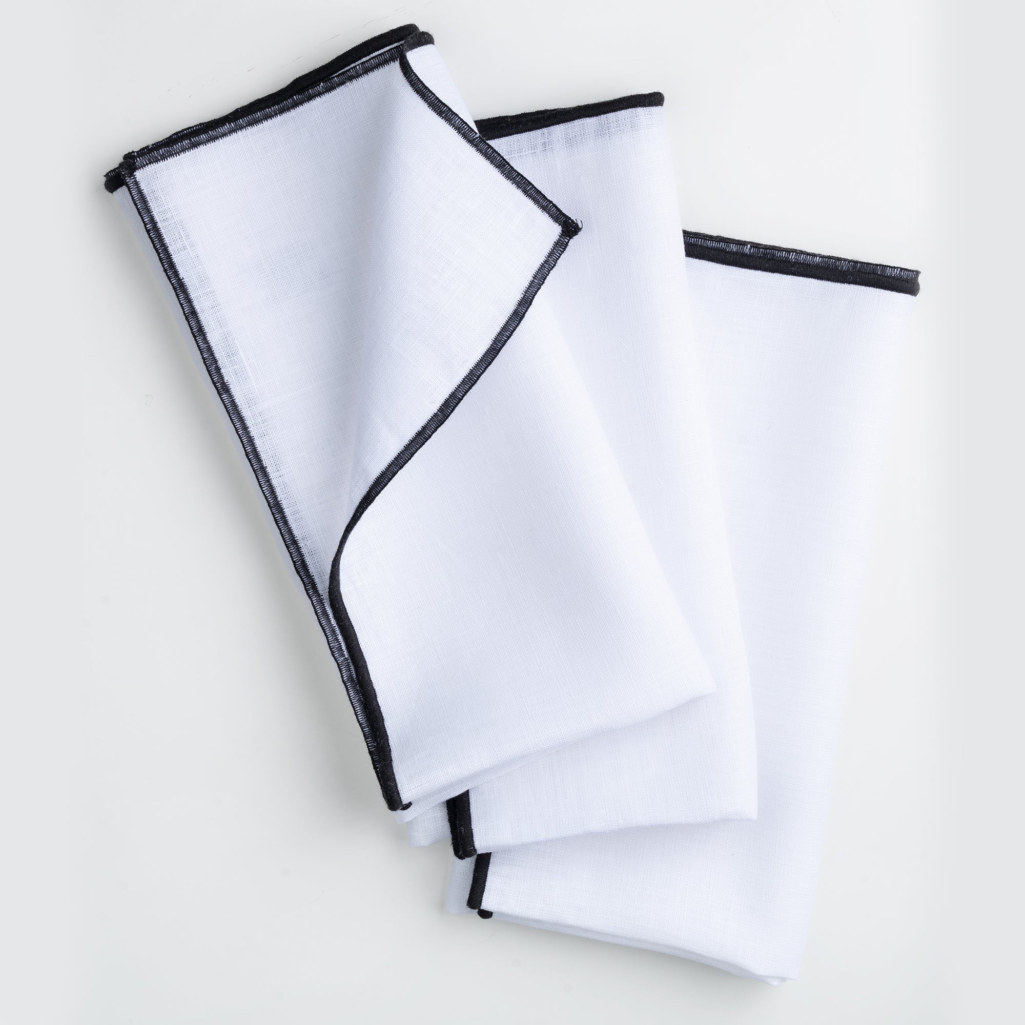 Close-up of the marrow edge on white and black pure linen dinner napkins