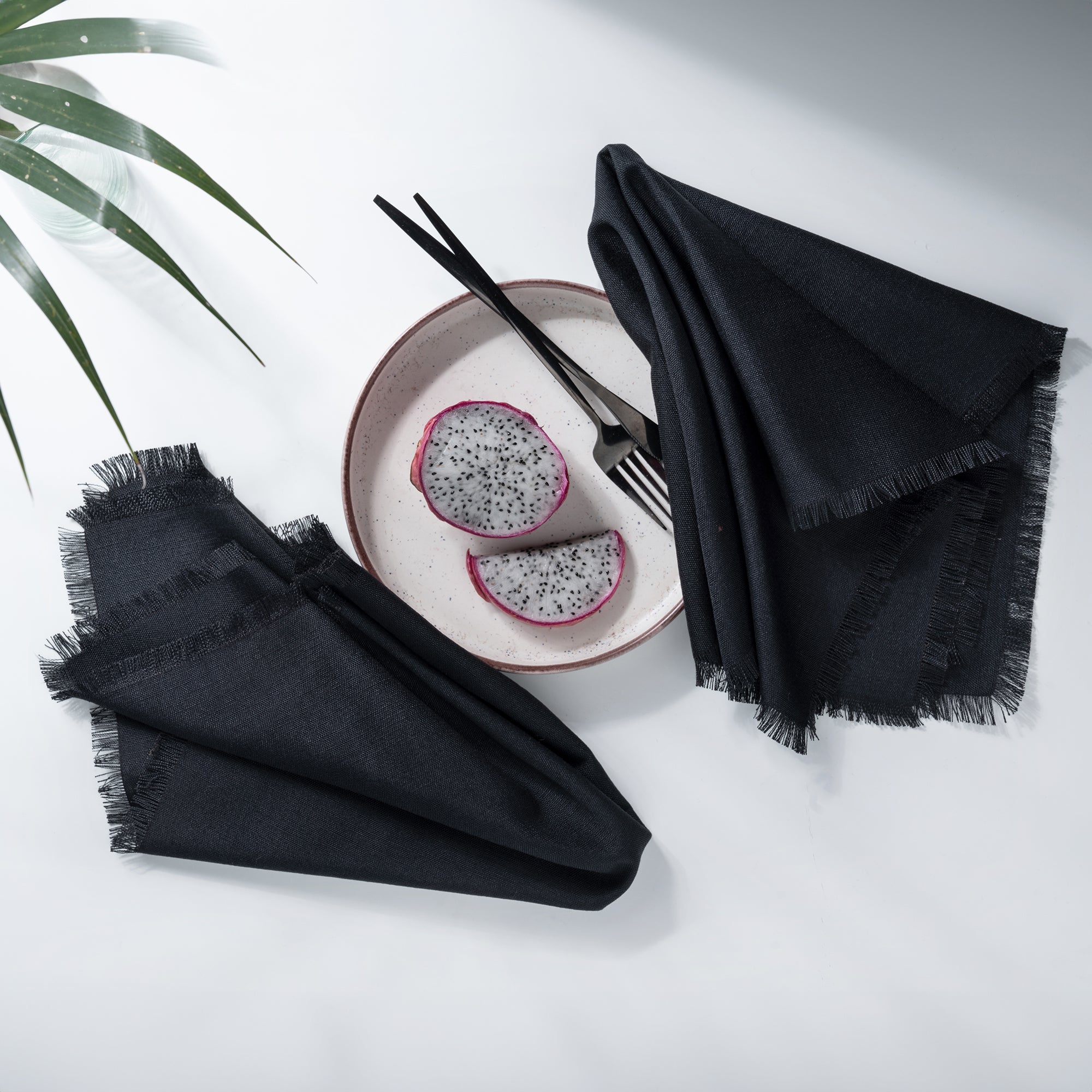 Close-up of the fringed edge on black faux linen dinner napkins