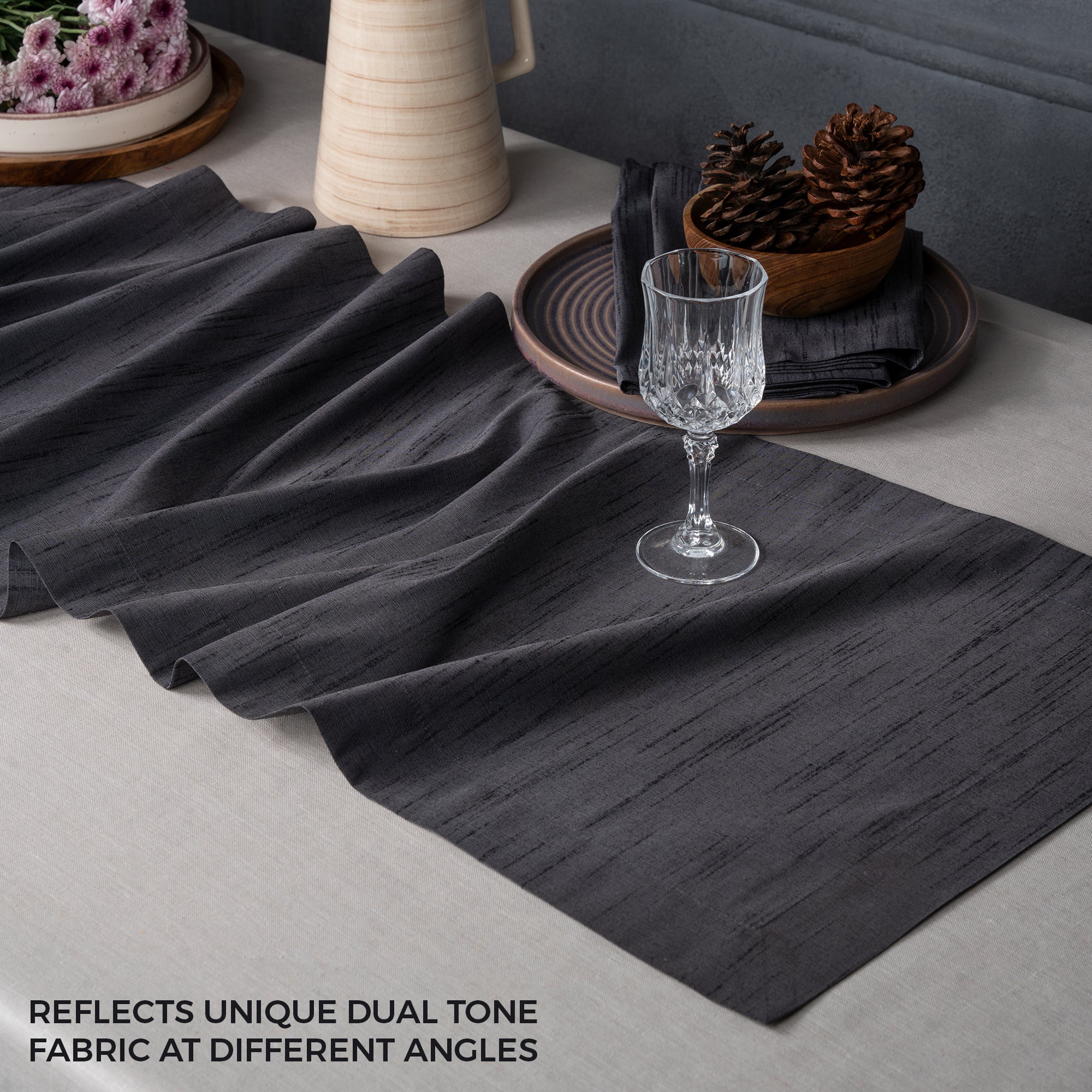 Close-up of the mitered corners on a charcoal grey Luxe Shine table runner