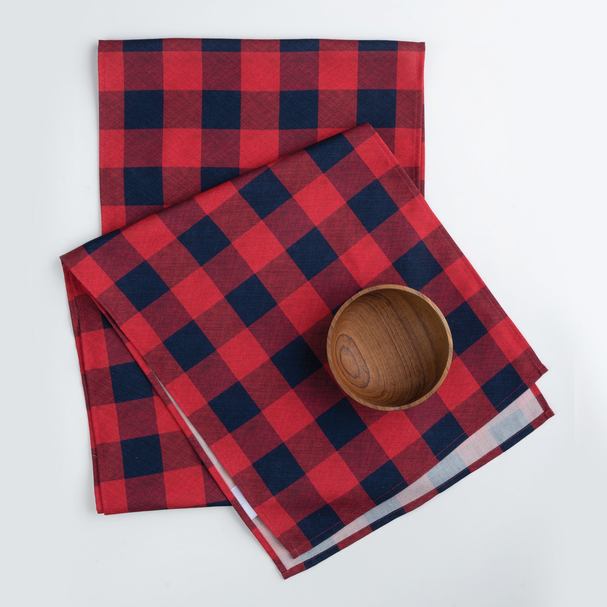 Close-up of the buffalo check pattern on a red and navy blue linen table runner