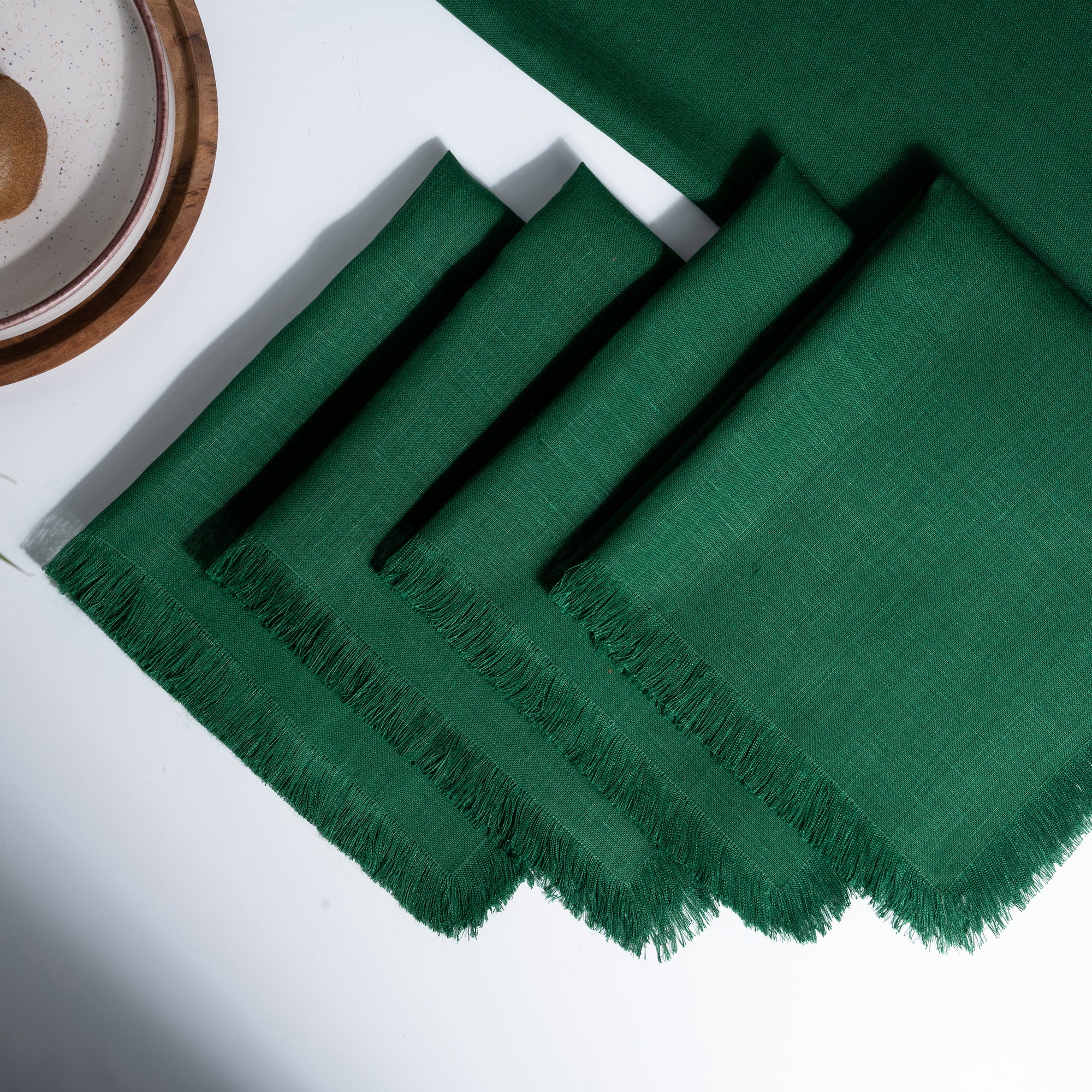 Forest green pure linen dinner napkins styled on a dining table