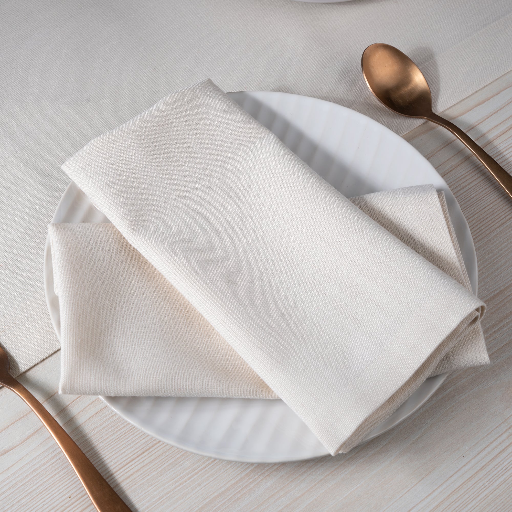 Ivory faux linen dinner napkins with matching D'Moksha table linens