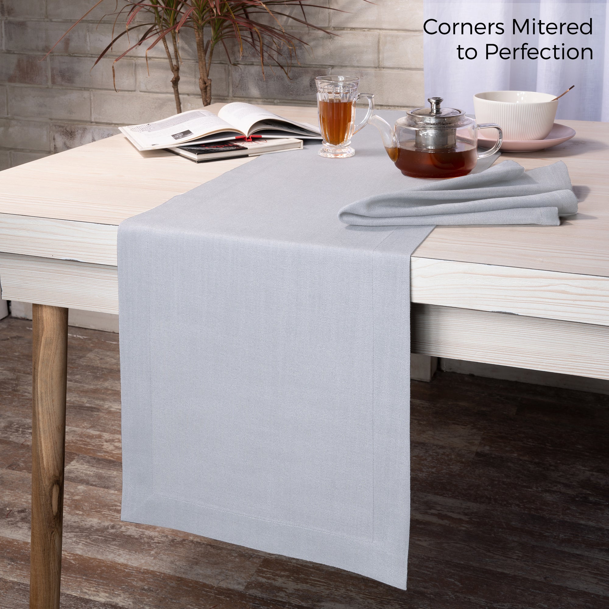 Light grey faux linen table runner styled on a dining table