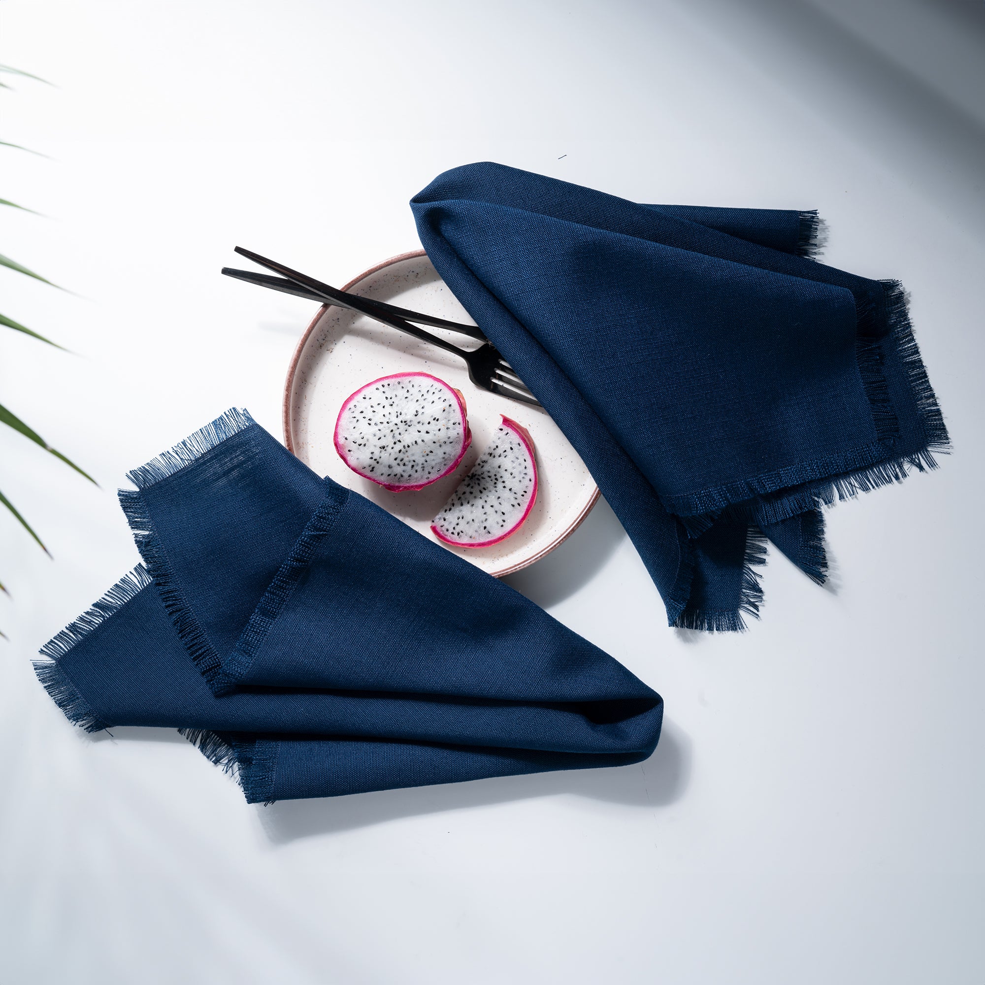 Close-up of the fringed edge on navy blue faux linen dinner napkins