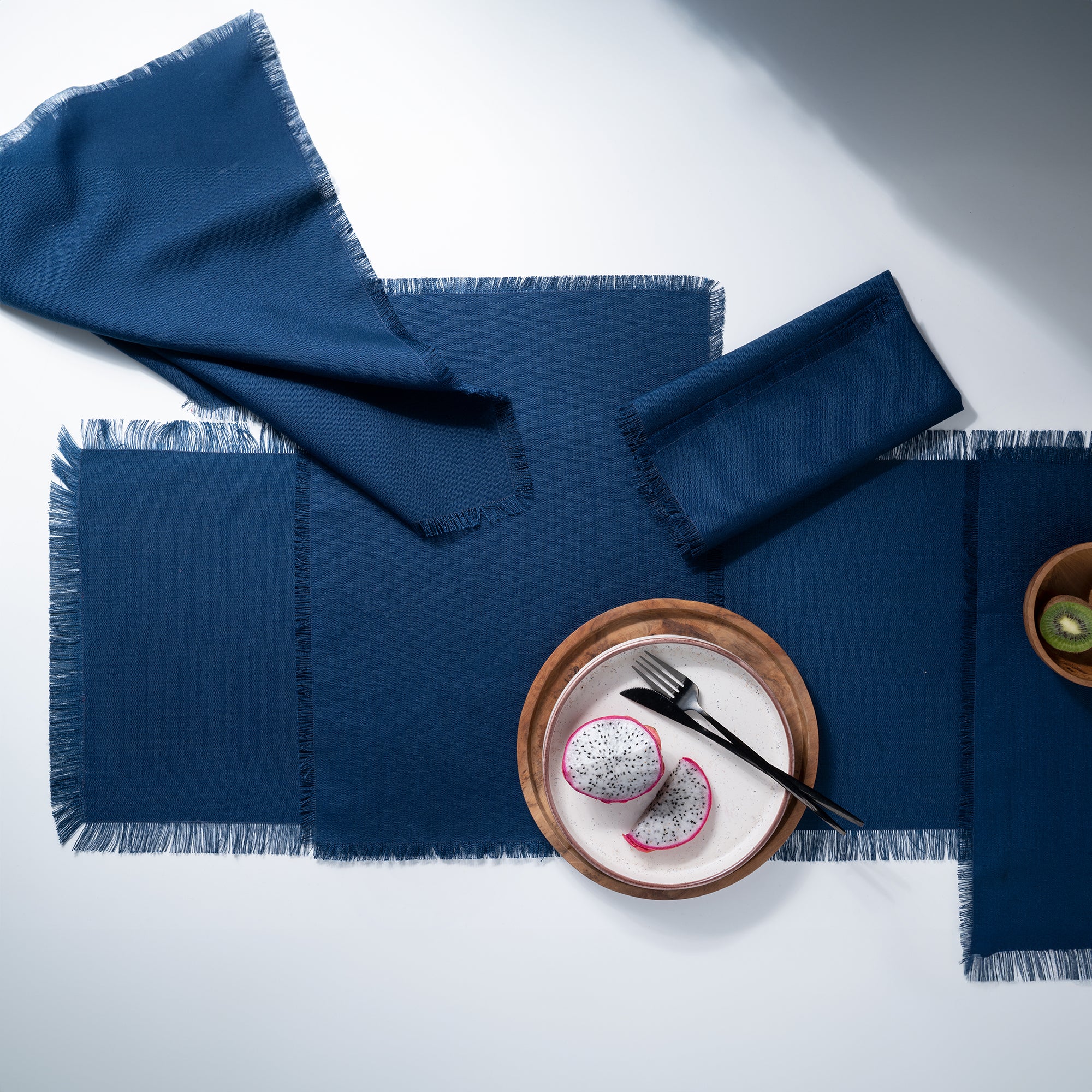 Navy blue faux linen placemats folded to show fabric texture