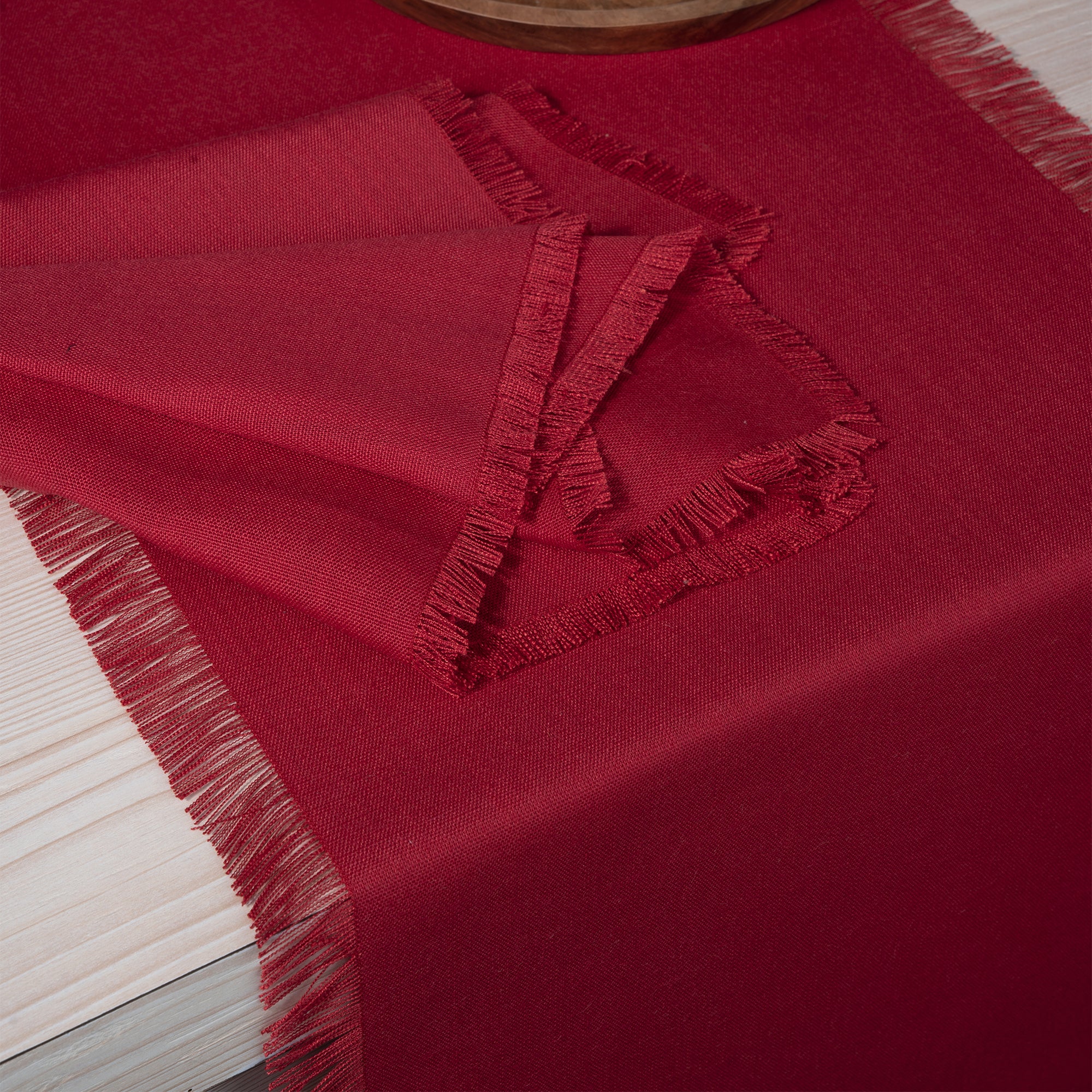 Close-up of the fringed edge on a red faux linen table runner