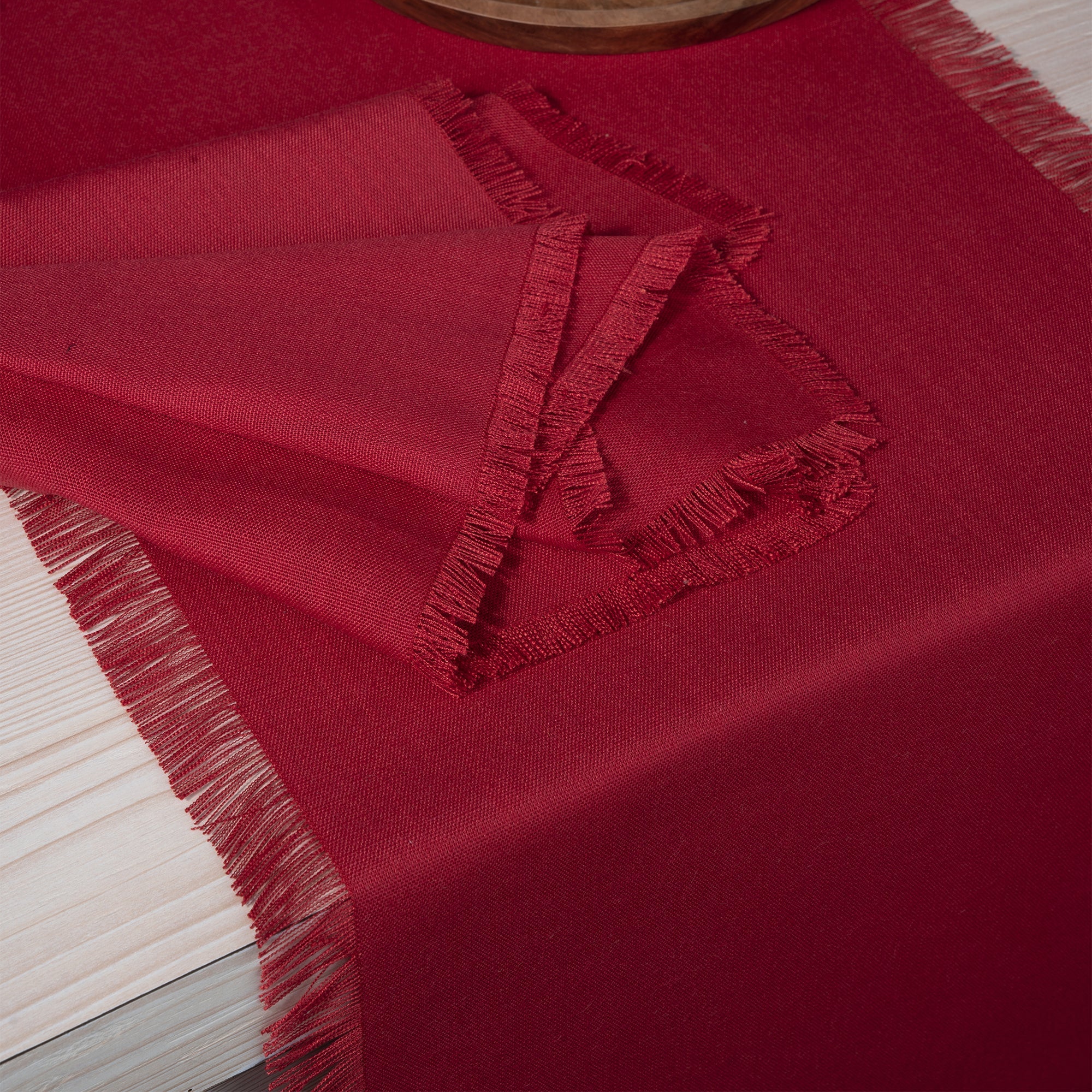 Close-up of the fringed edge on a red linen table runner