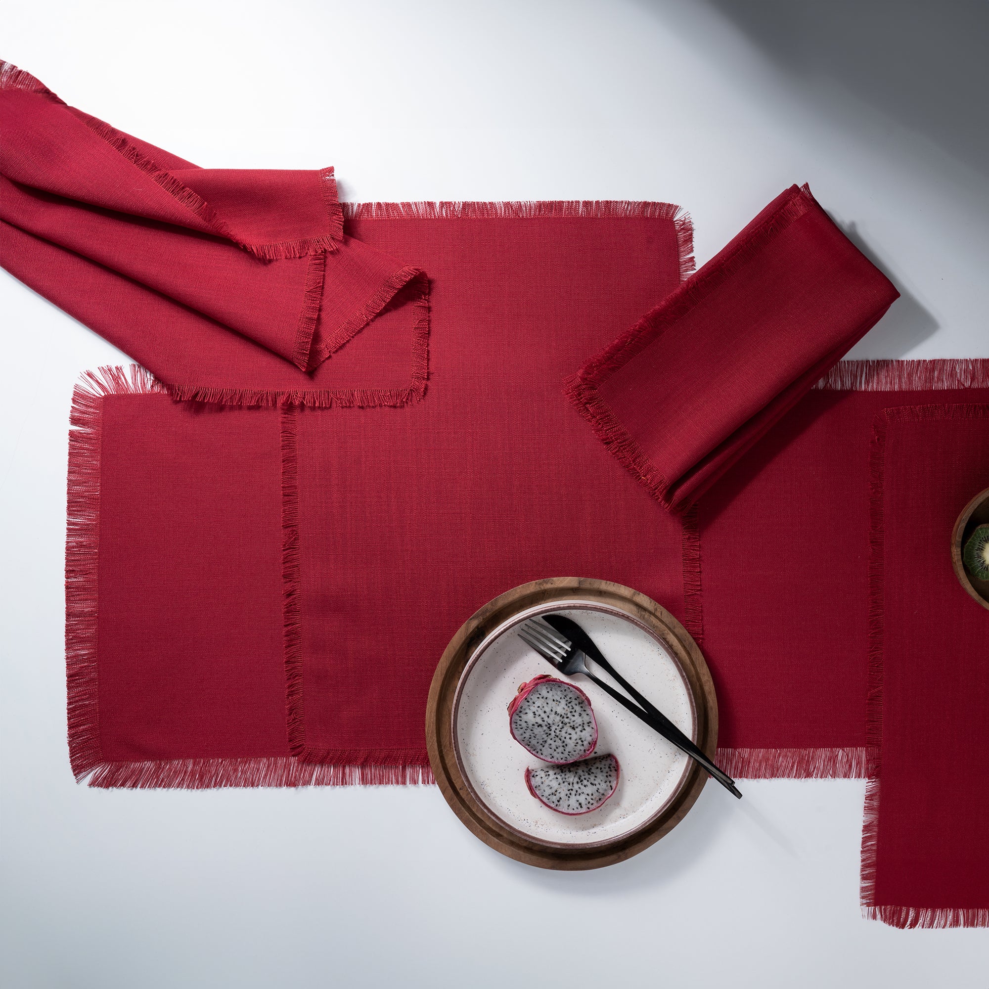 Red faux linen placemats folded to show fabric texture
