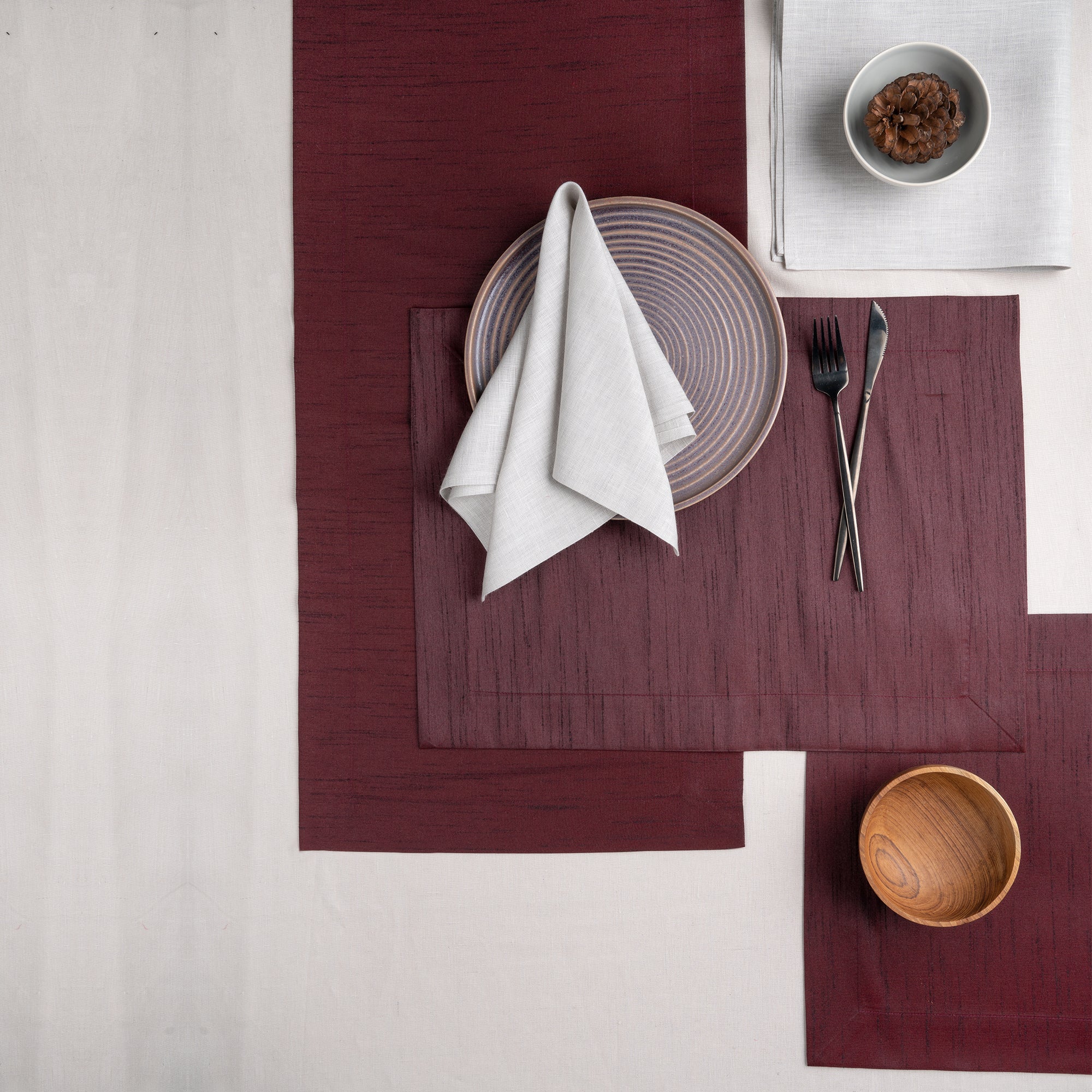 Close-up of the mitered corners on wine red Luxe Shine placemats