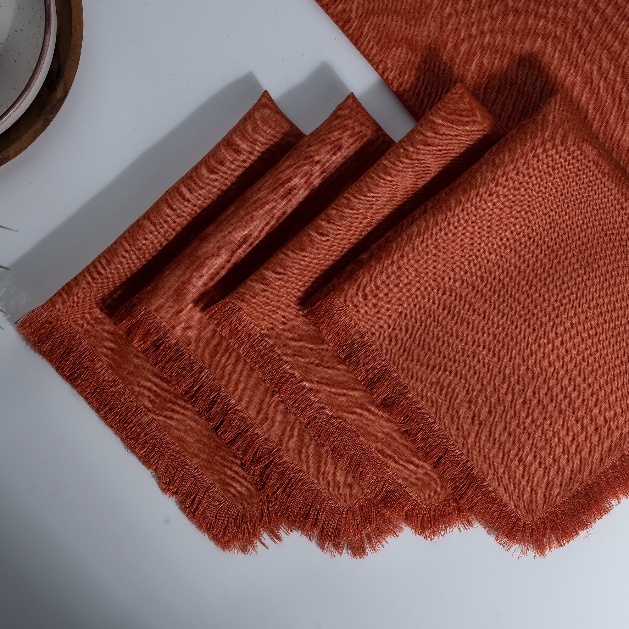 Rust pure linen dinner napkins styled on a dining table