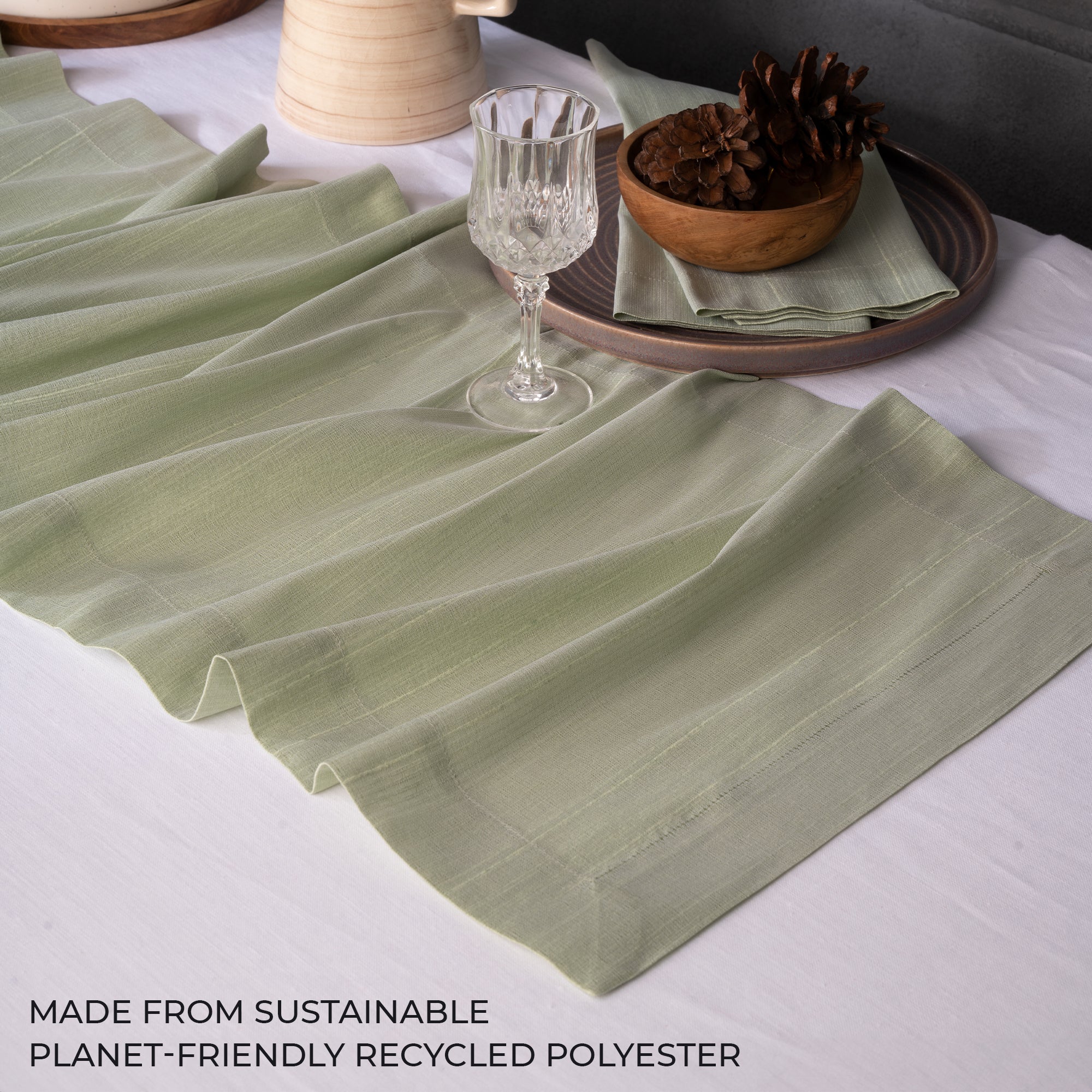 Close-up of the mitered corners on a sage green Luxe Shine table runner